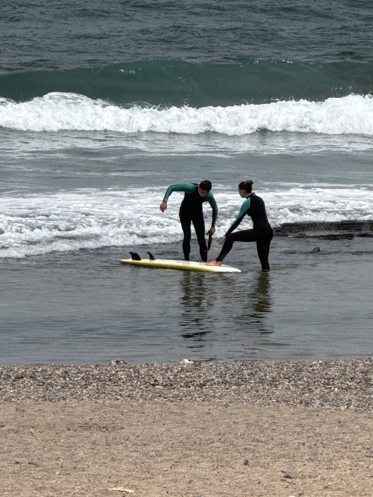 Arona beach day: surfers, lifeguard tower, and promenade life