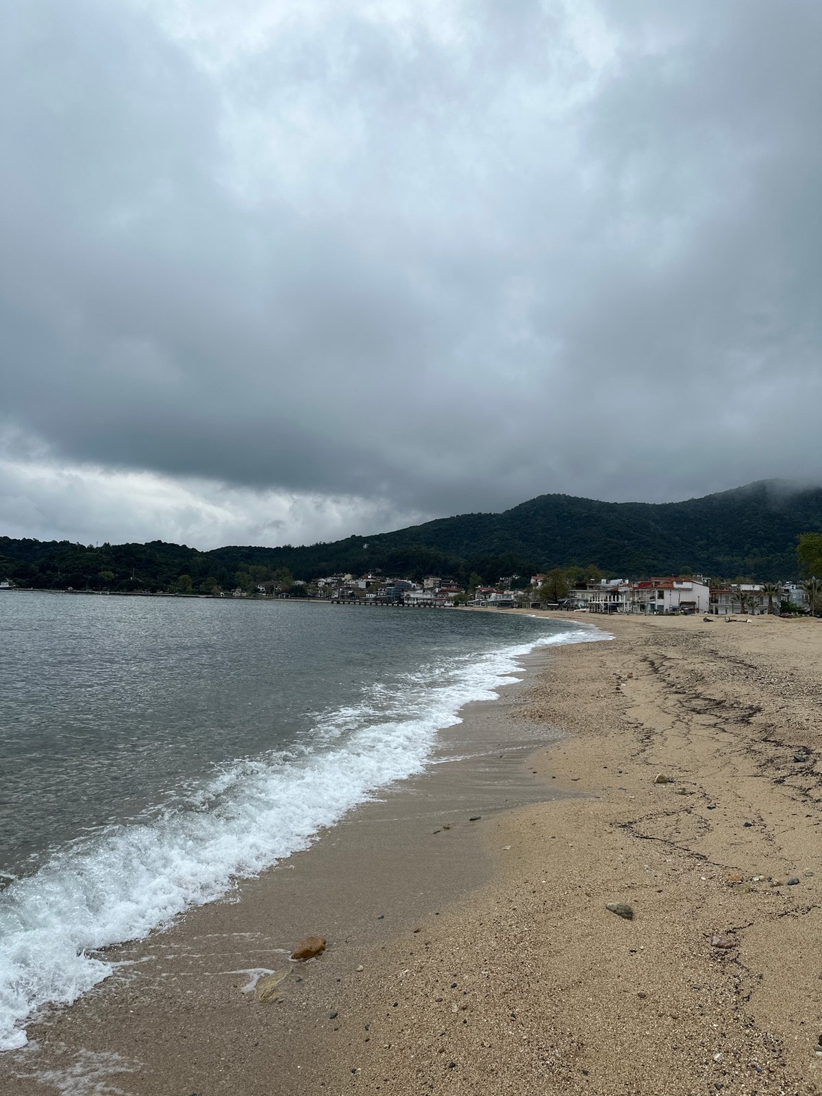 Beachcomber collects seashells on Greek pebble shore