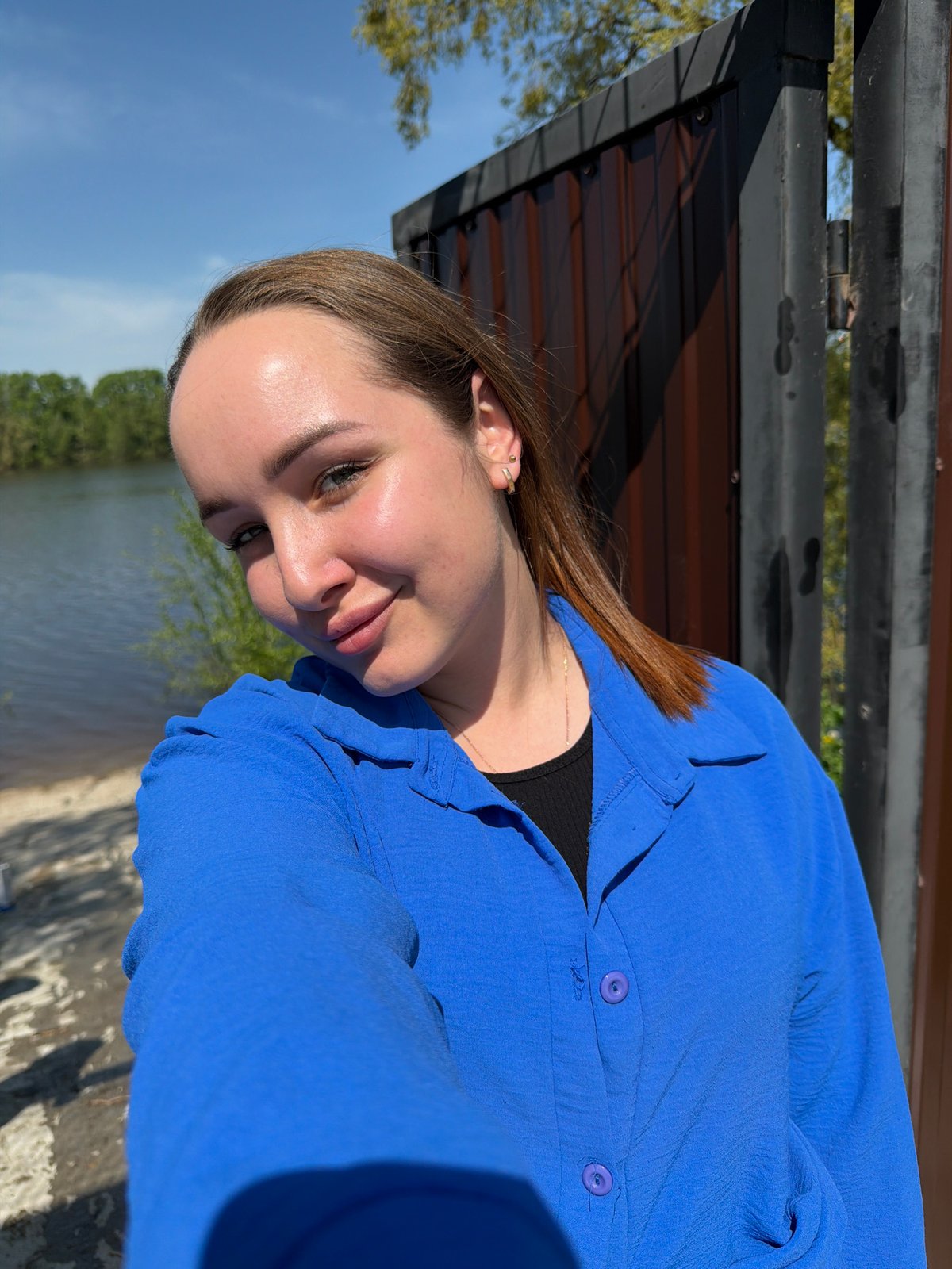 Woman sits by water in Chaikovsky, Russia spring morning