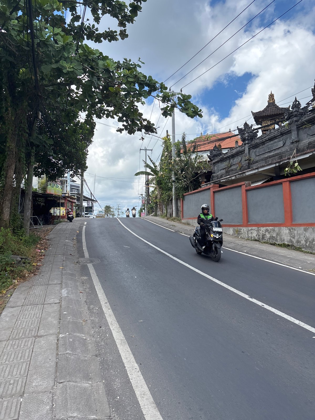 Tourist documents daytime street life in Kuta Selatan