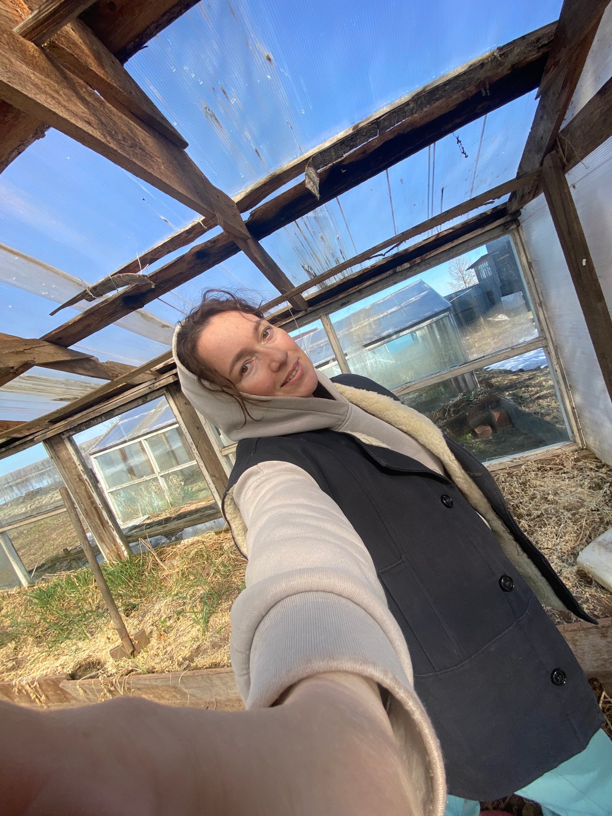 Woman photographs herself at abandoned greenhouse in rural Russia
