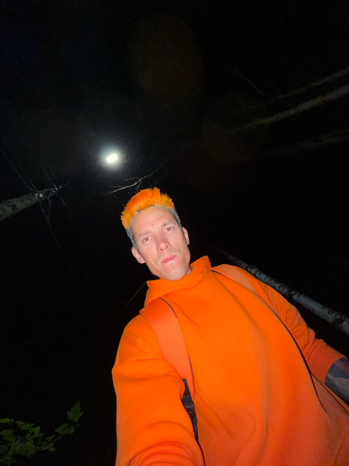 Orange-haired individual documents nighttime walk through Chaikovsky, Russia