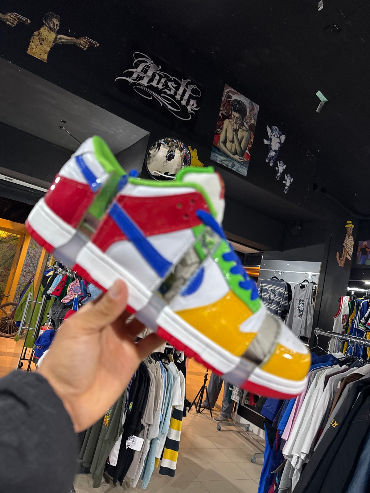Shopper examines colorful sneaker at Barcelona streetwear store
