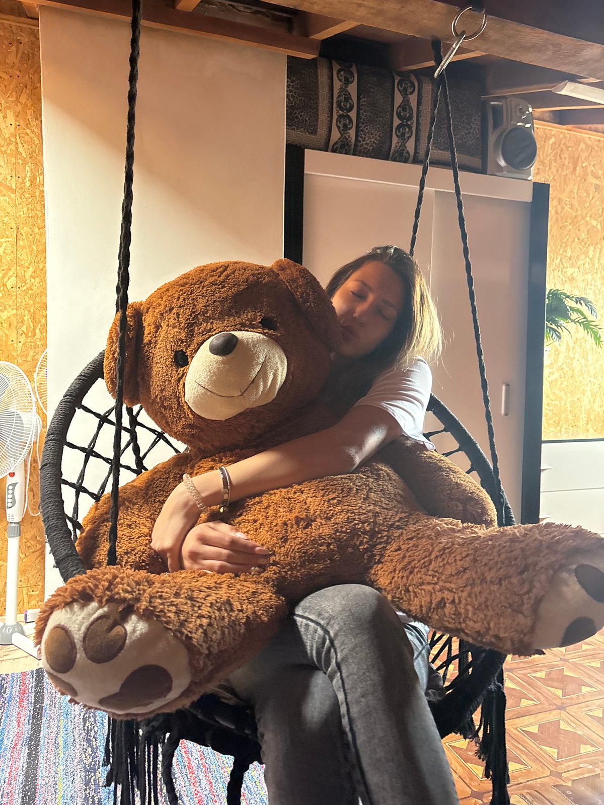 Woman with bandaged arm rests in swing chair, Tervel