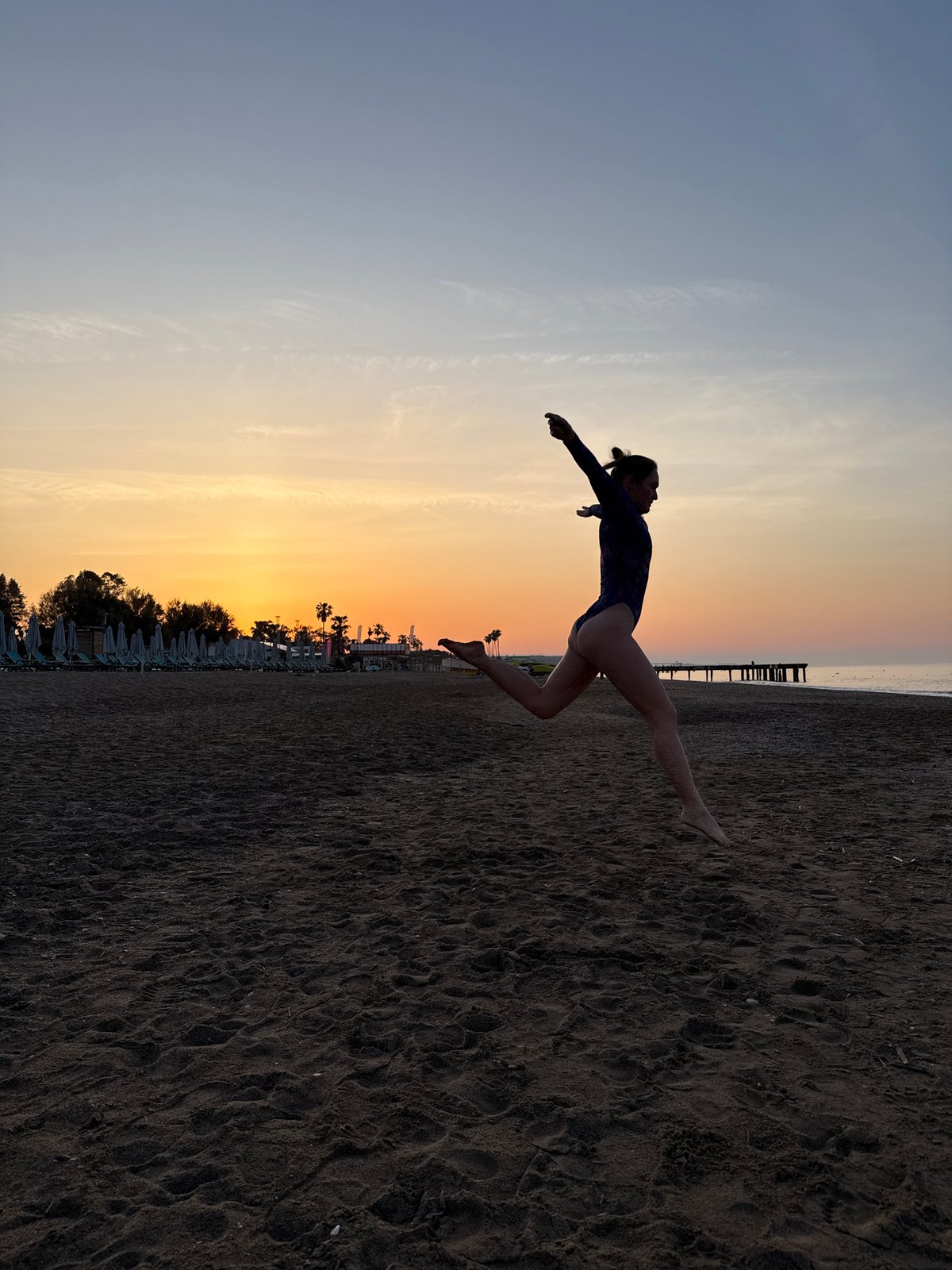 Woman performs dance routine on Turkish beach at sunrise