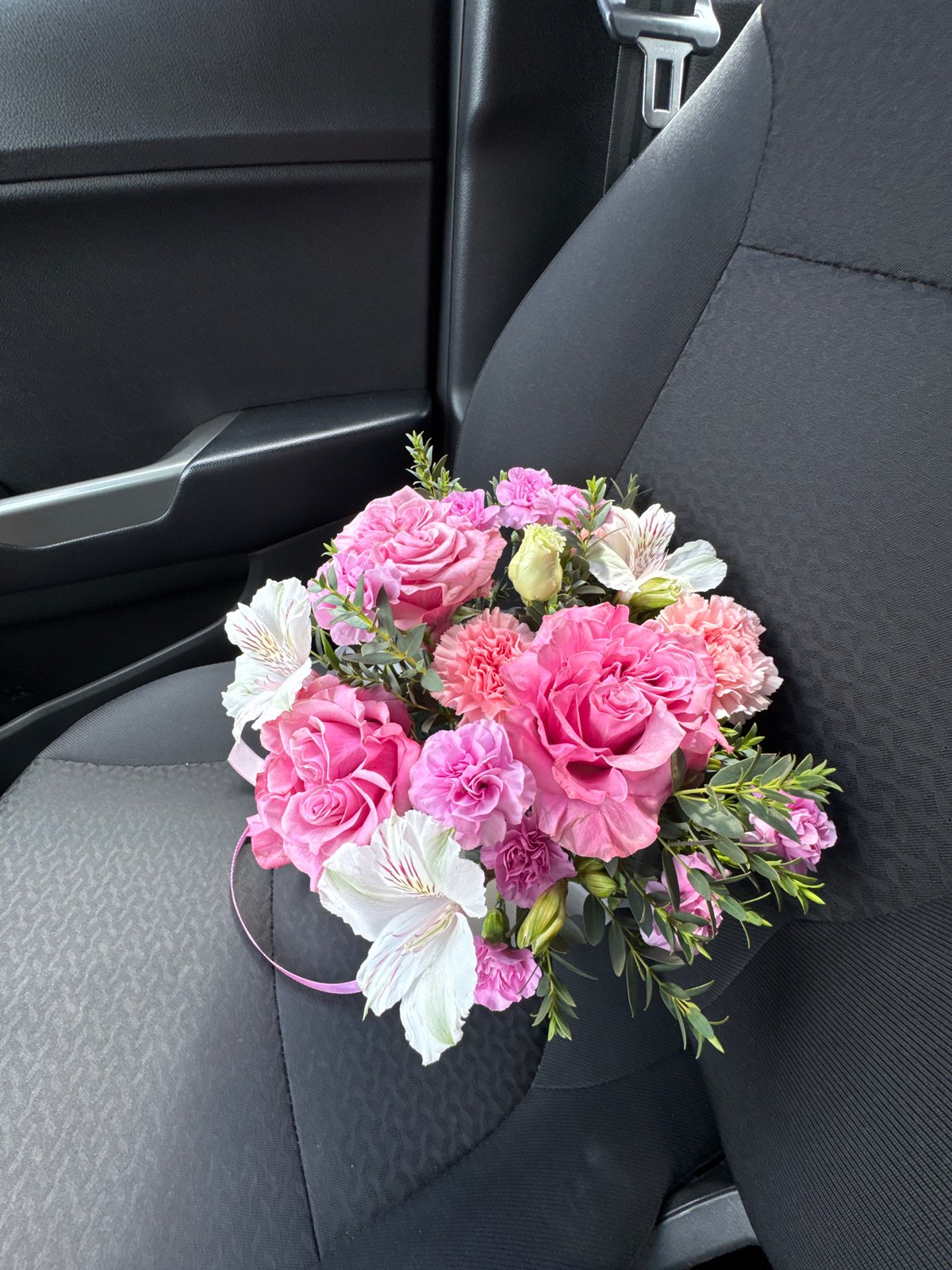 Woman photographed with flower bouquet in car, Izhevsk