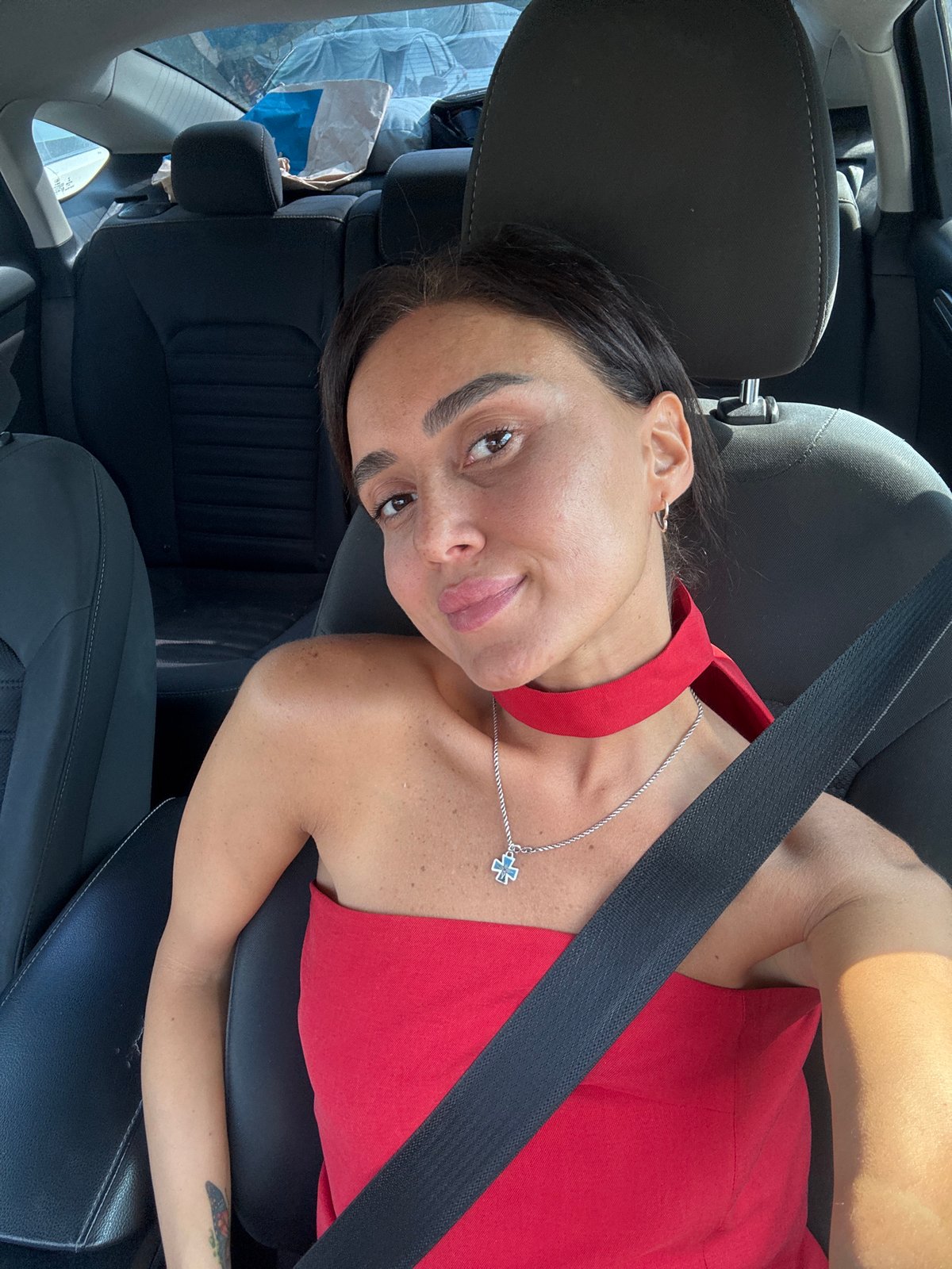Inside a car in Tbilisi, red top, silver necklace