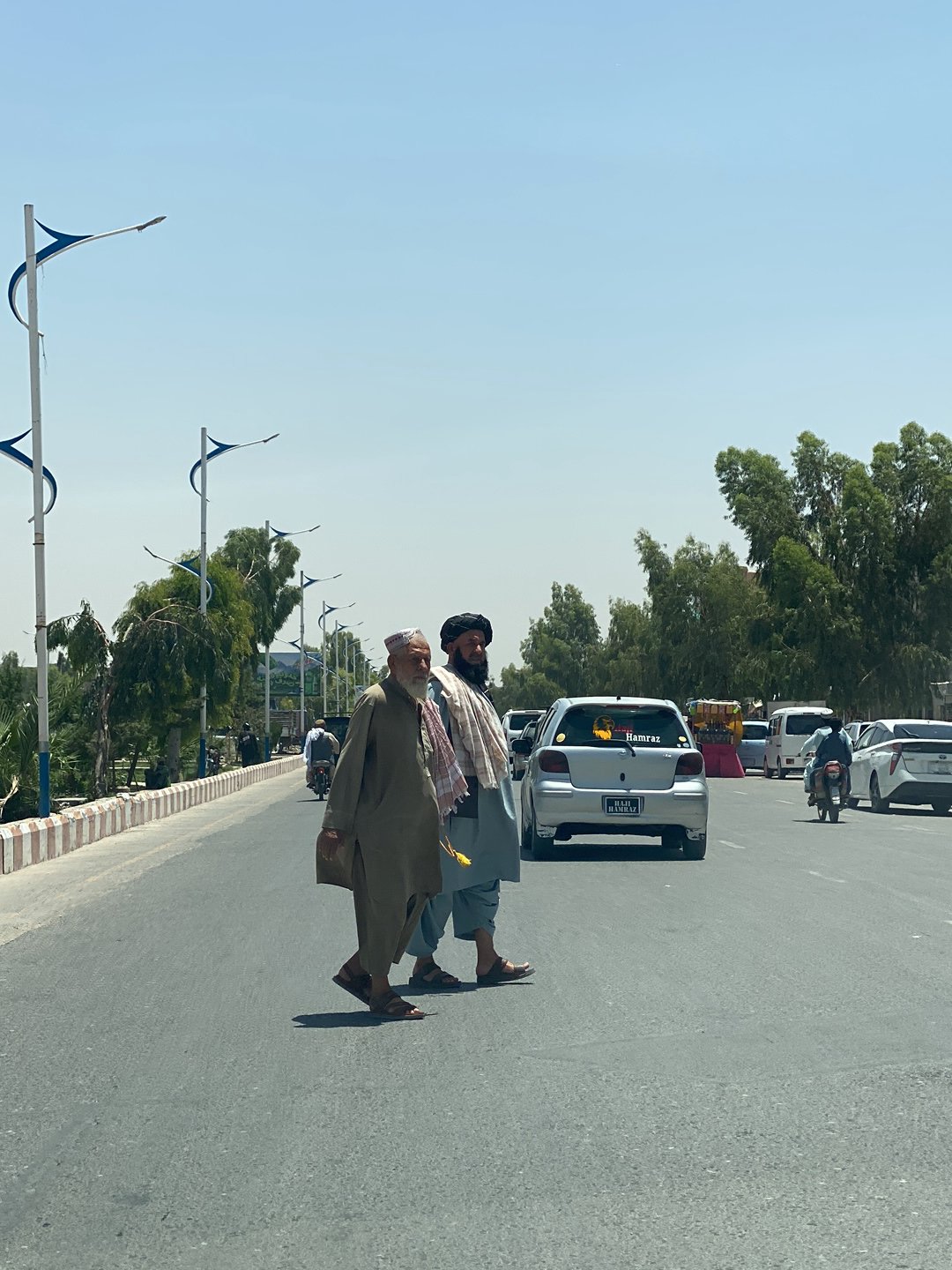Two men cross street in Kandahar morning scene