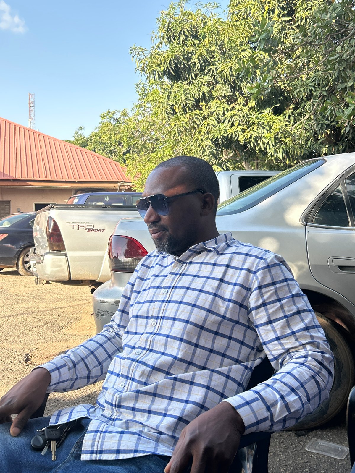 Men gather around table in Jos, Nigeria afternoon
