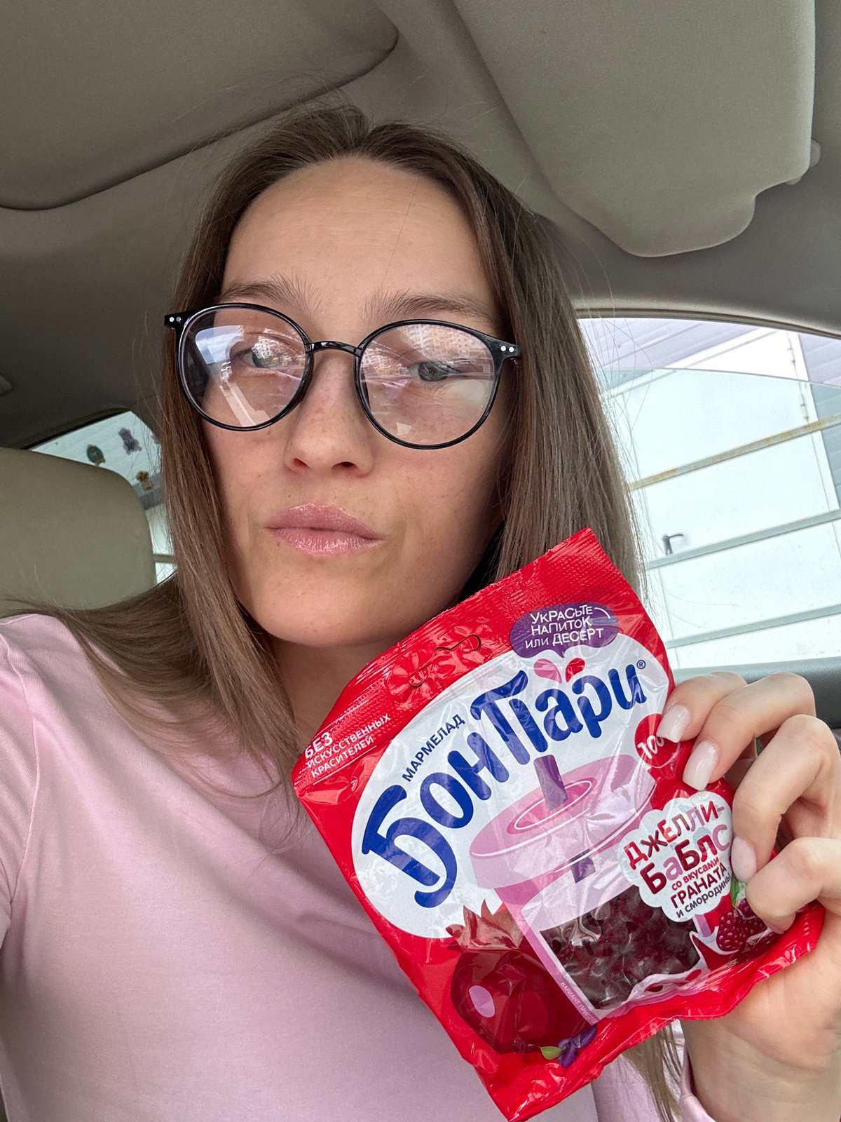 Woman holds jelly candy package in car, Novorossiysk