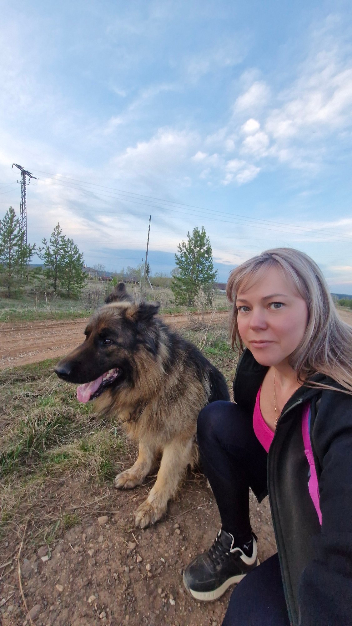 Woman walks German Shepherd on rural road near Otchor