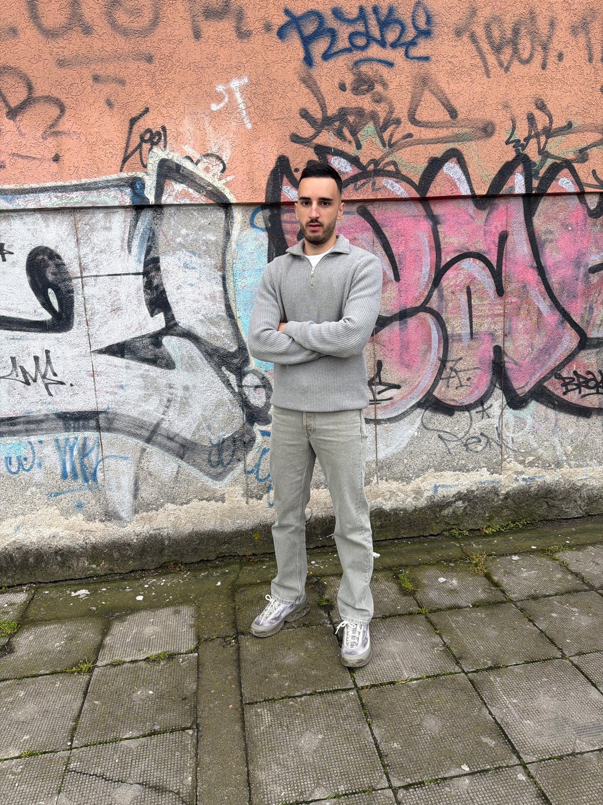 Young man poses for casual photos near graffiti in Plovdiv
