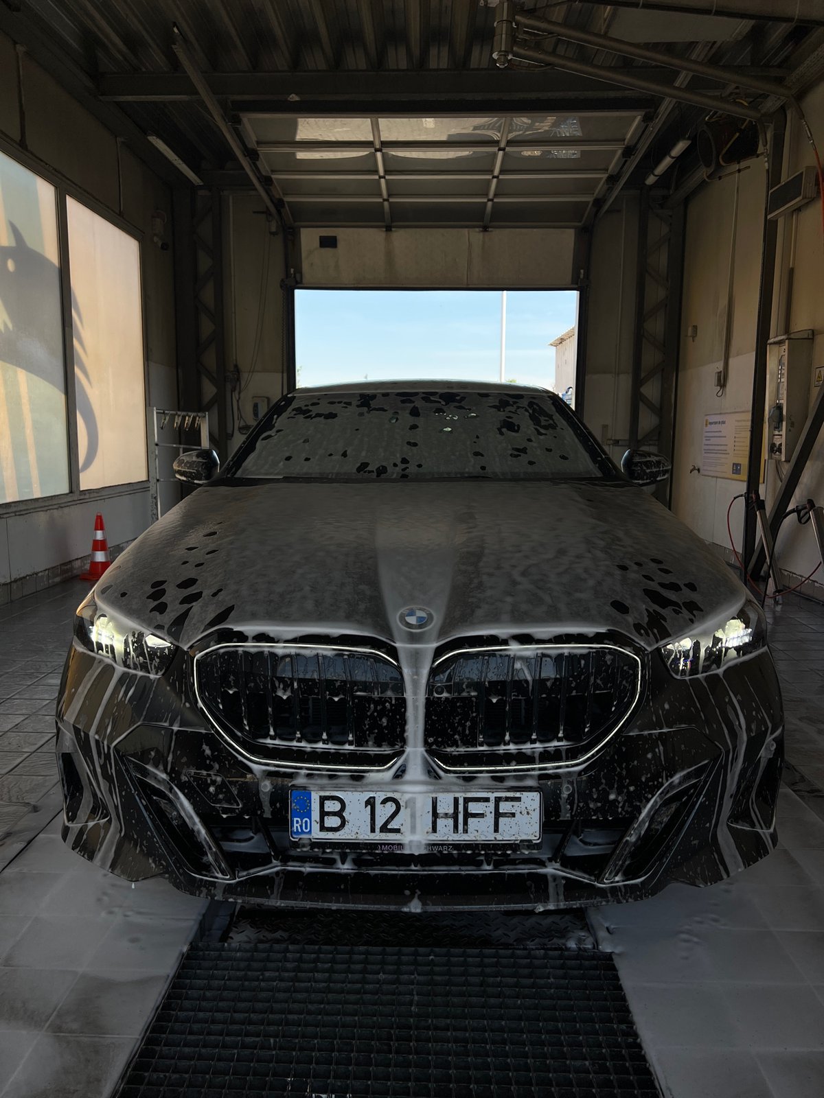 Black BMW mid-wash at a Cluj-Napoca car wash