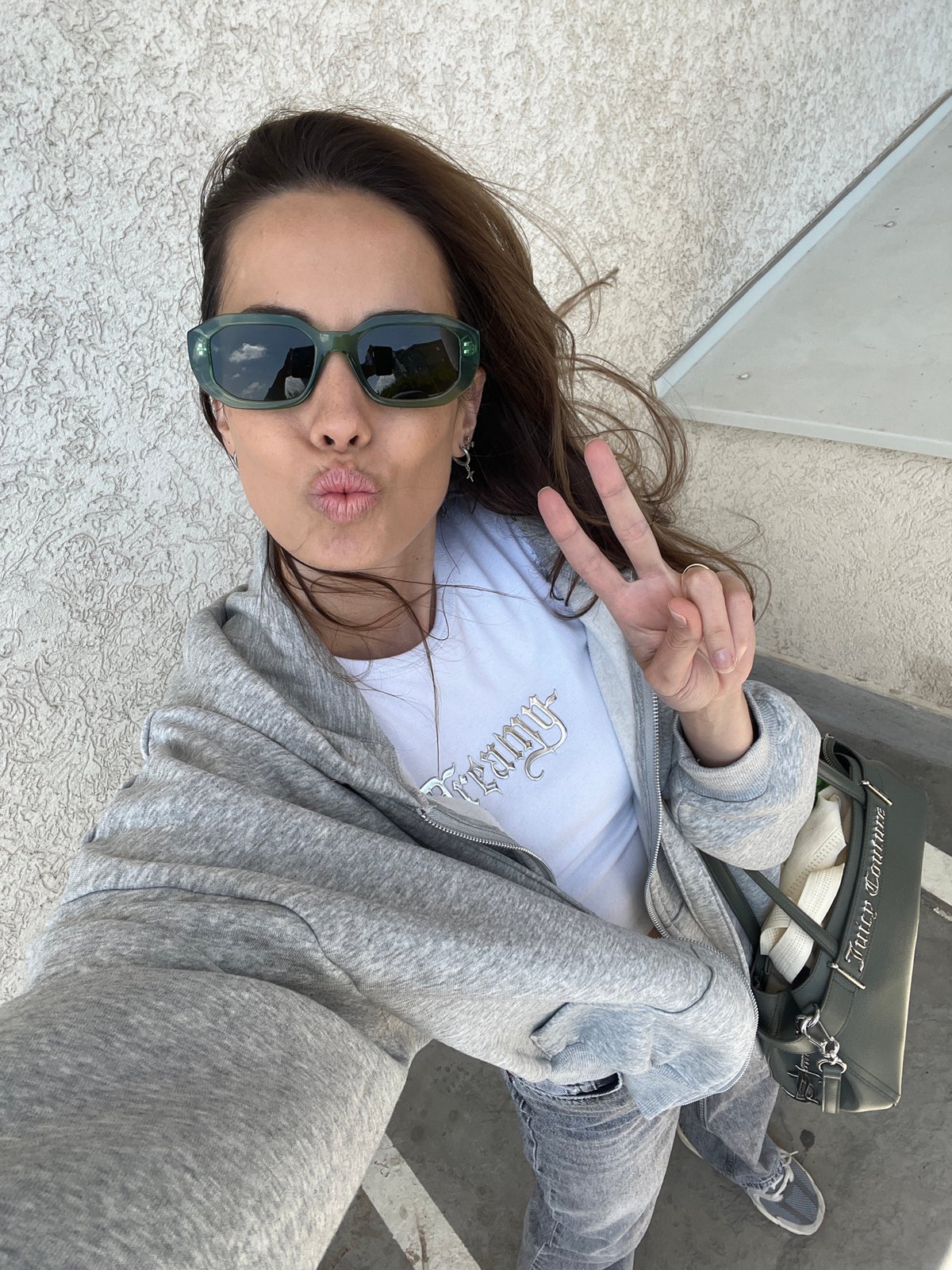 Woman takes selfie with peace sign in Bjeliši, Montenegro