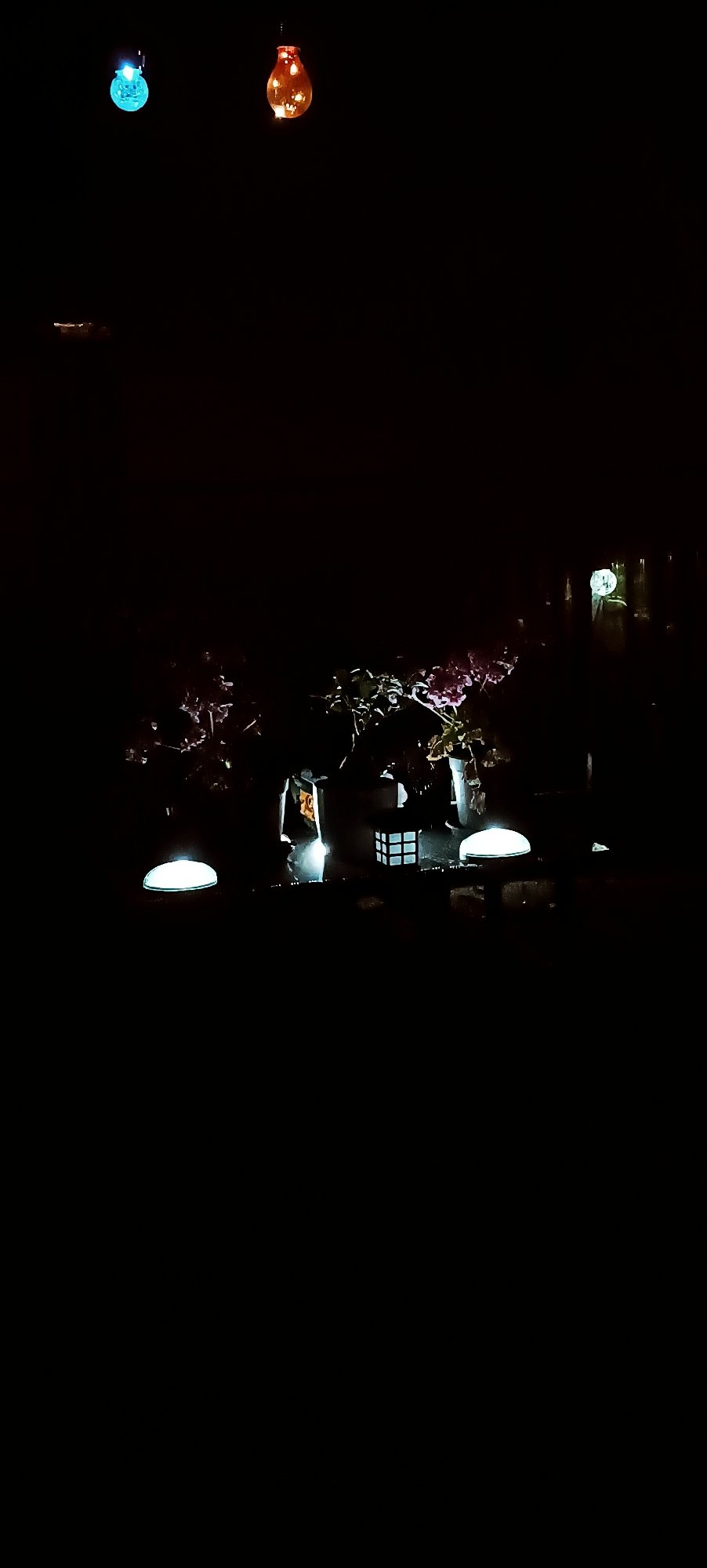 Backyard night scene with string lights and a paper lantern