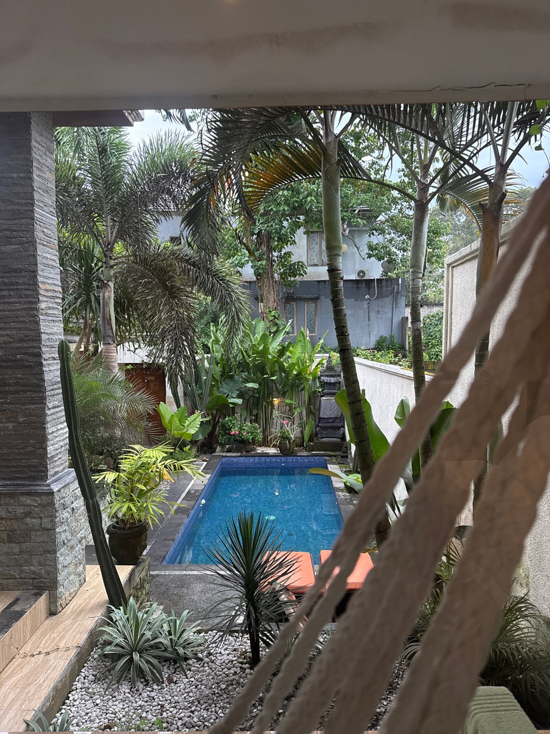 Tropical garden pool area observed from balcony in Kuta Selatan
