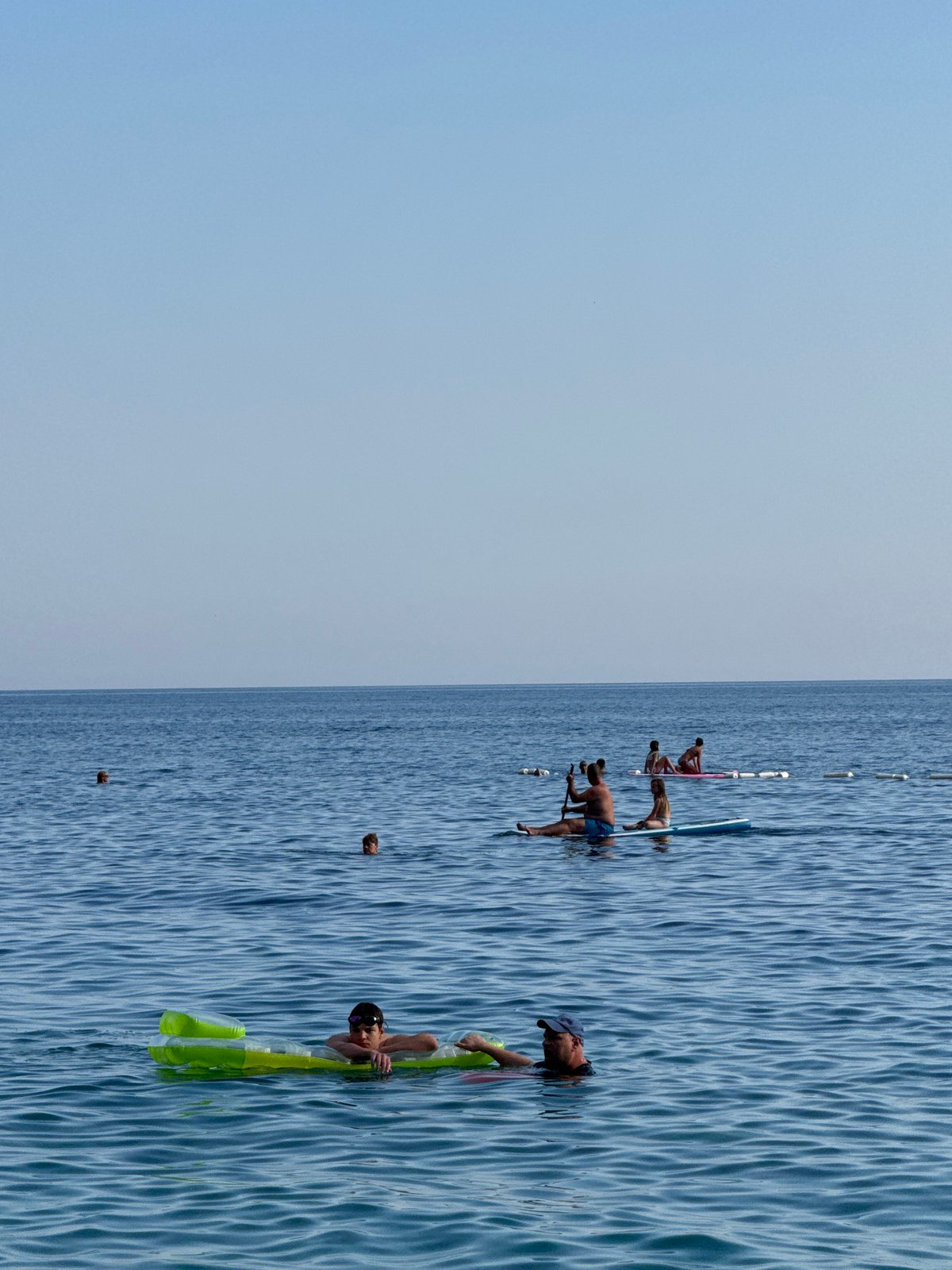 Busy summer beach day in Mirište, graffiti ruin looming behind