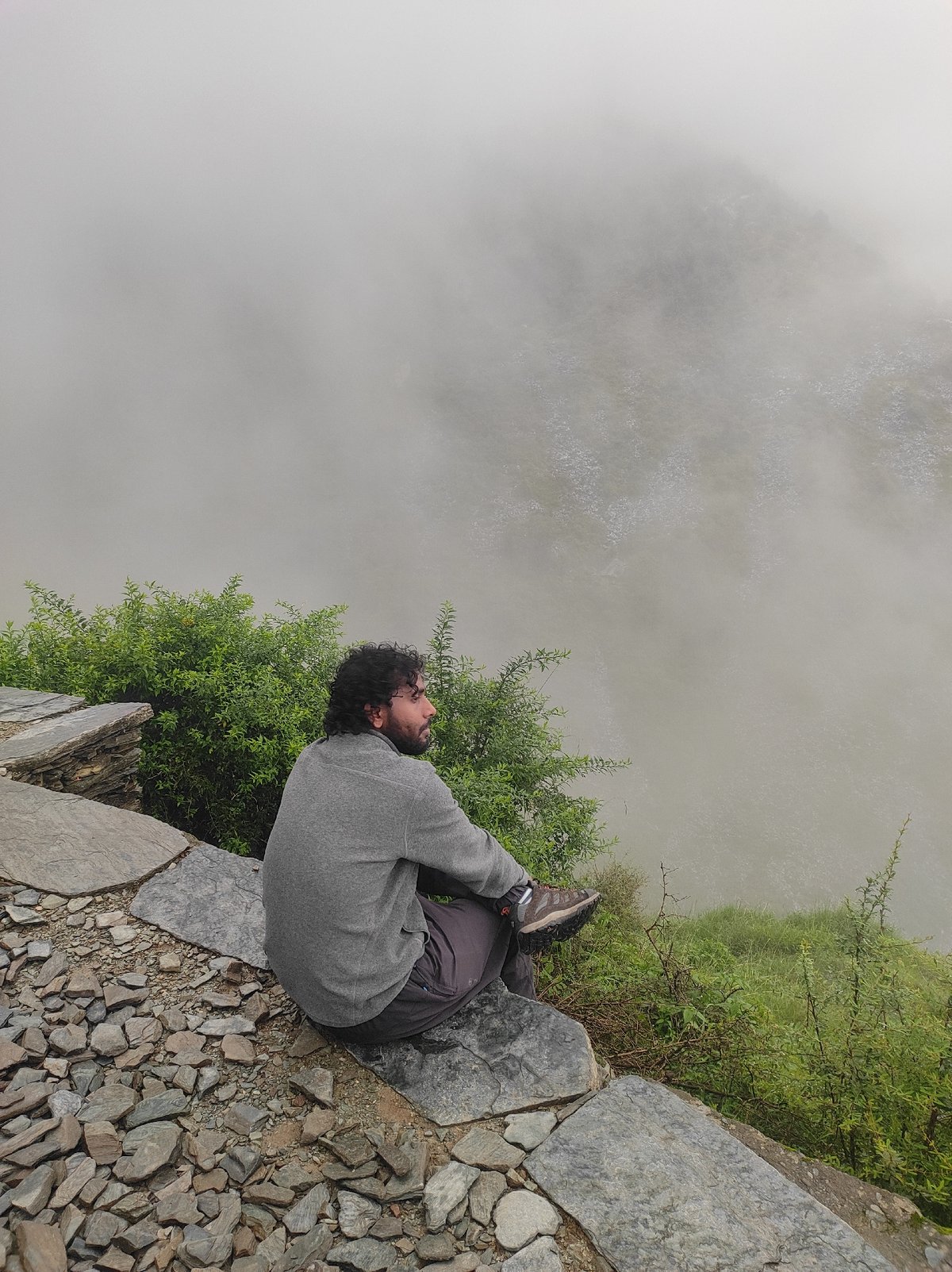 Sitting on a rocky ledge, gazing into fog