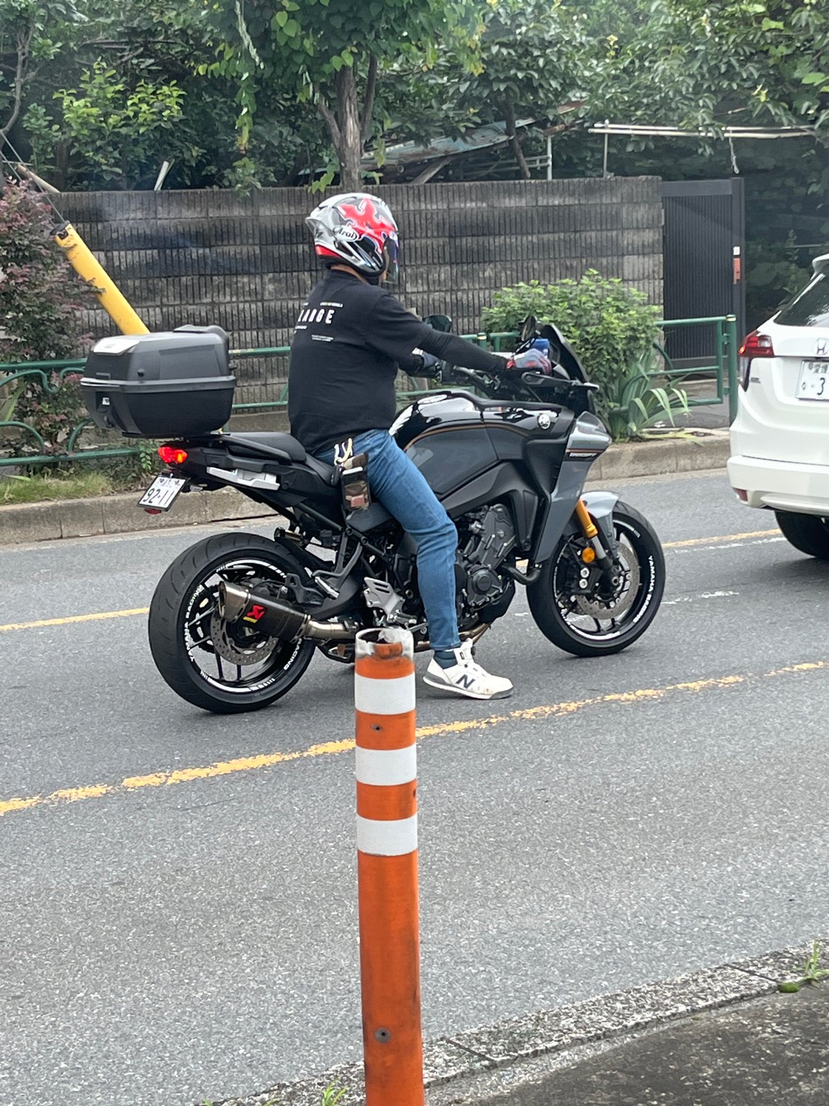 Sport-touring motorcycle with cargo box rolling through Nerima streets