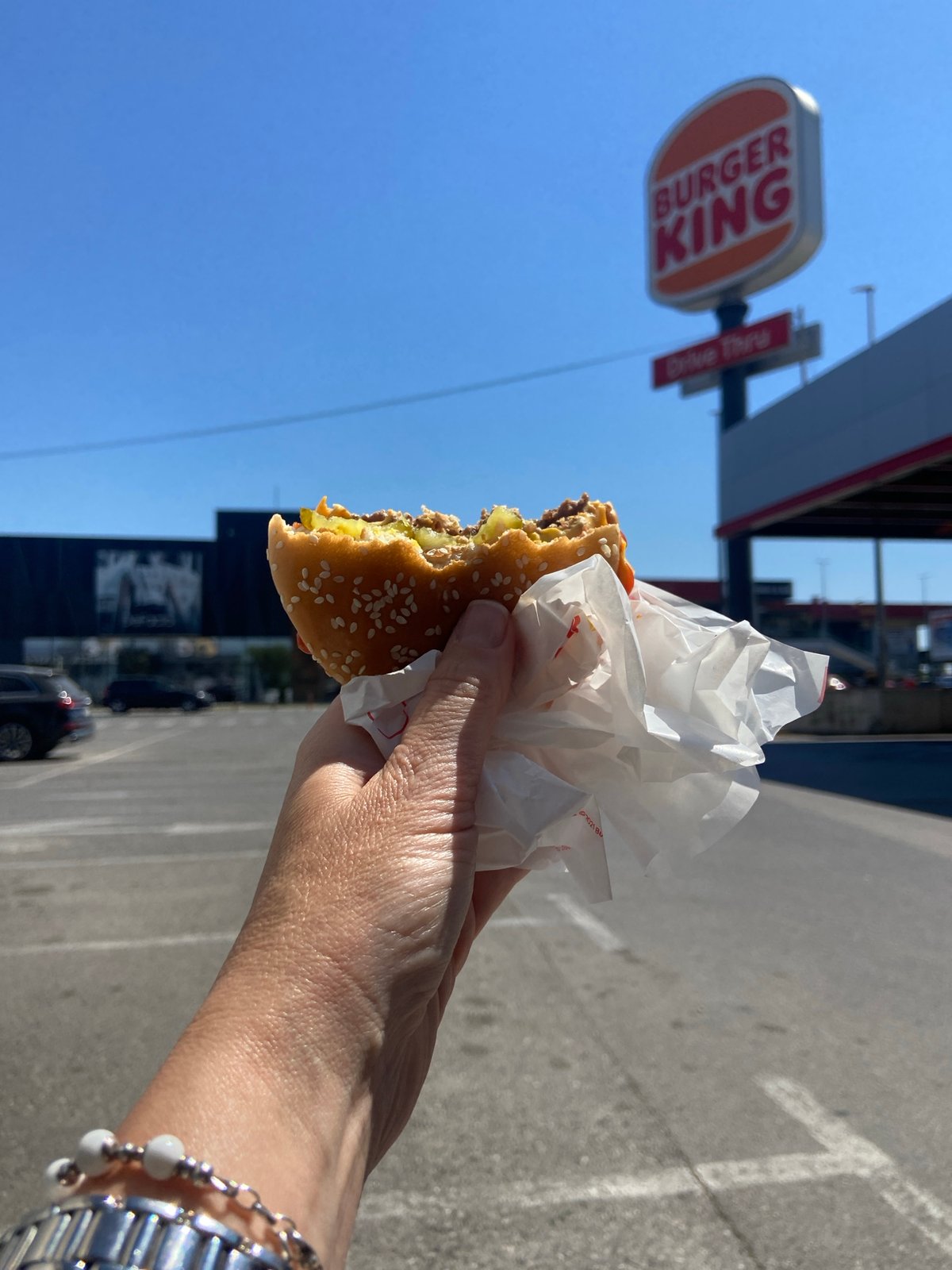 Person eats burger outside Burger King in Podgorica