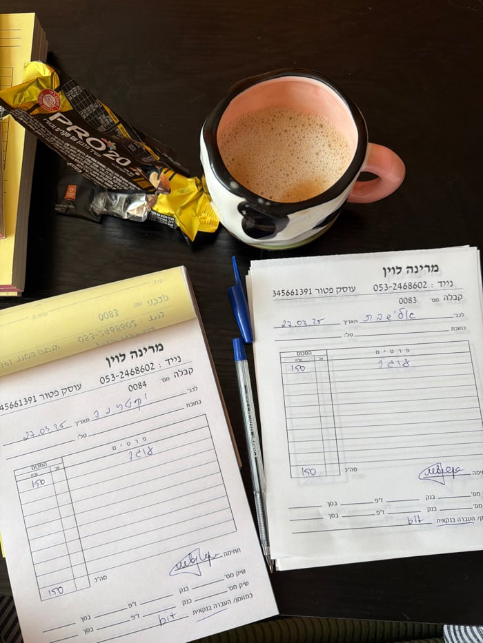 Woman works with documents on couch in Tel Aviv apartment