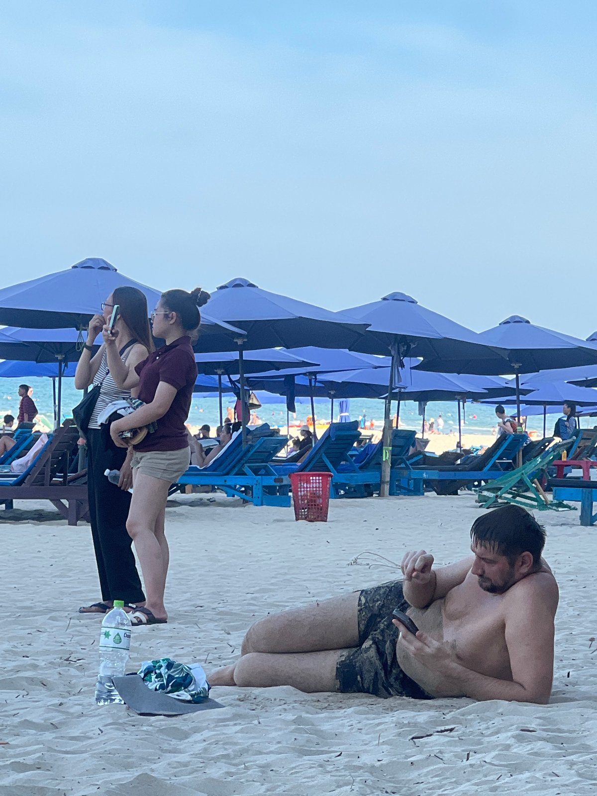 Busy morning at Đà Nẵng beach — swimming, sunbathing, parasailing