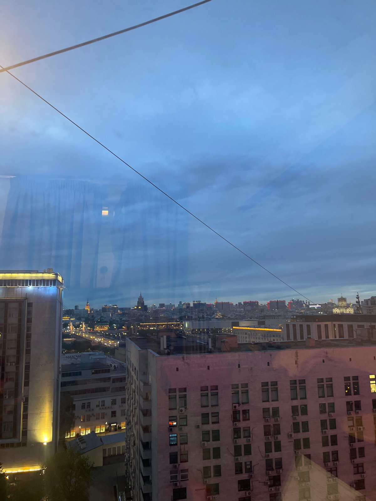 Moscow evening: cityscape view and woman on sofa