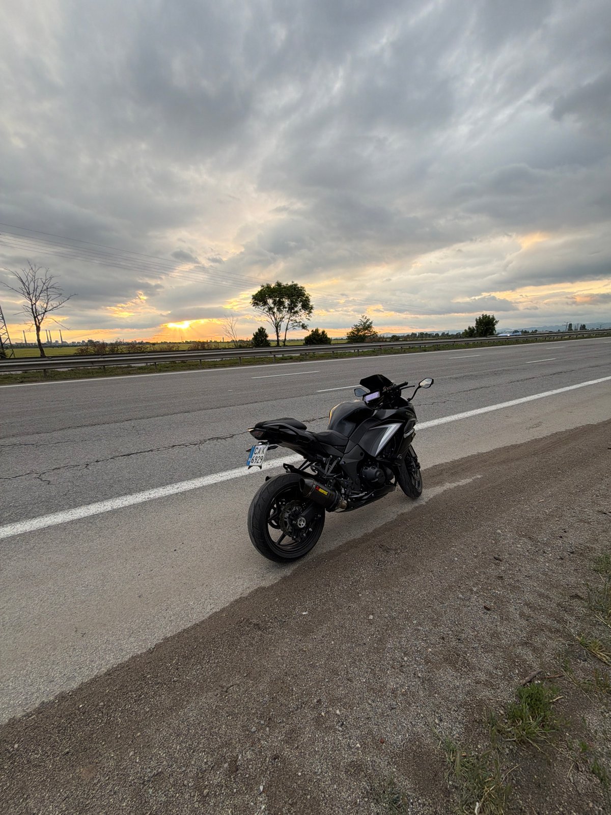 Black motorcycle parked on highway shoulder near Kazichene, Bulgaria