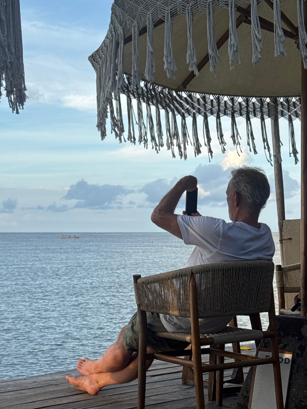 Tourist photographs ocean view at Nusa Penida beach bar