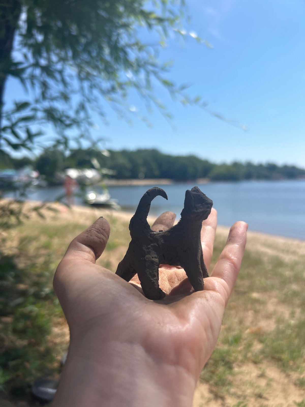Handmade clay cat figurine by the waterfront in Engels