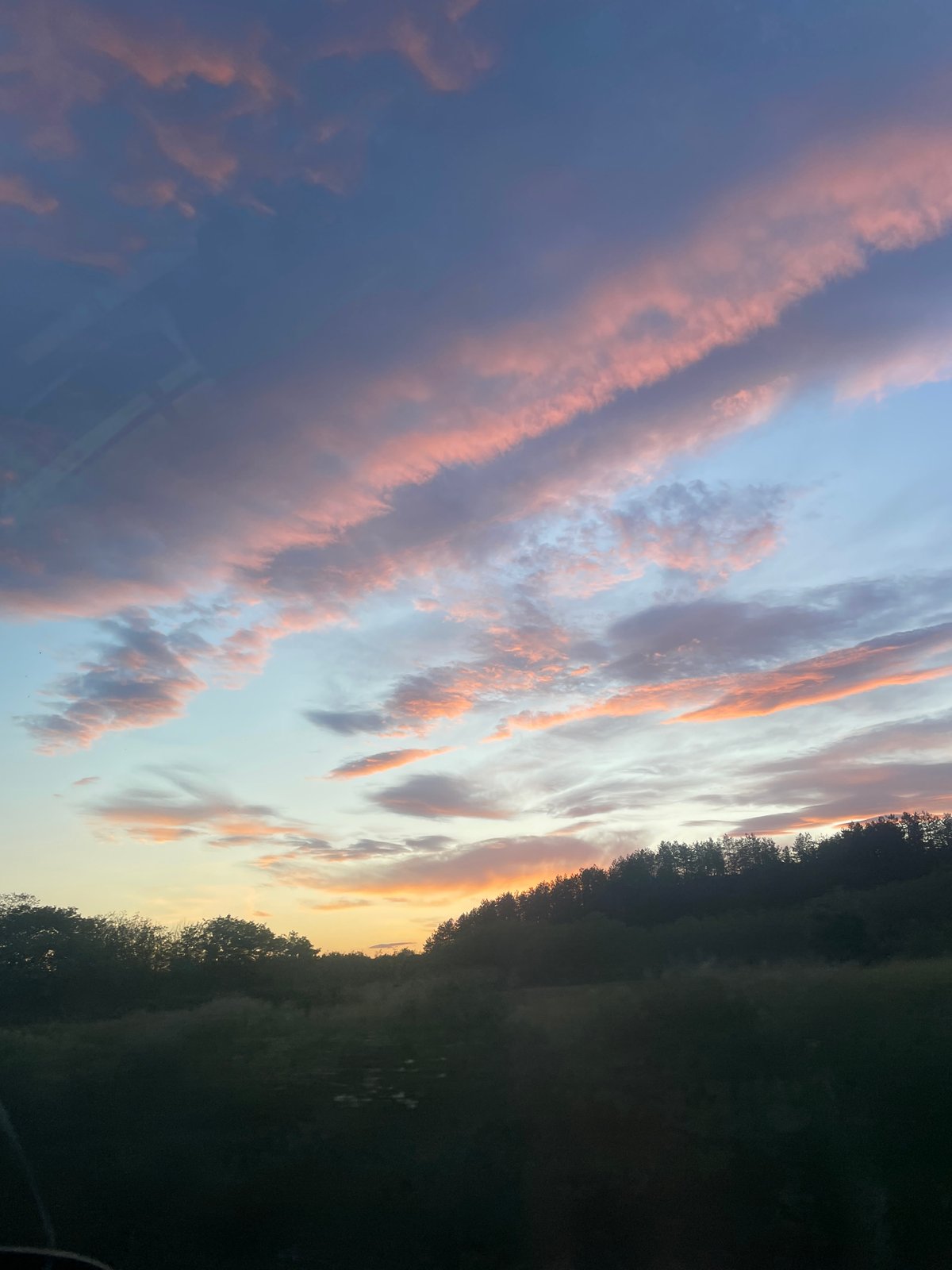 Sunset displays pink orange clouds over Kalofer Bulgaria
