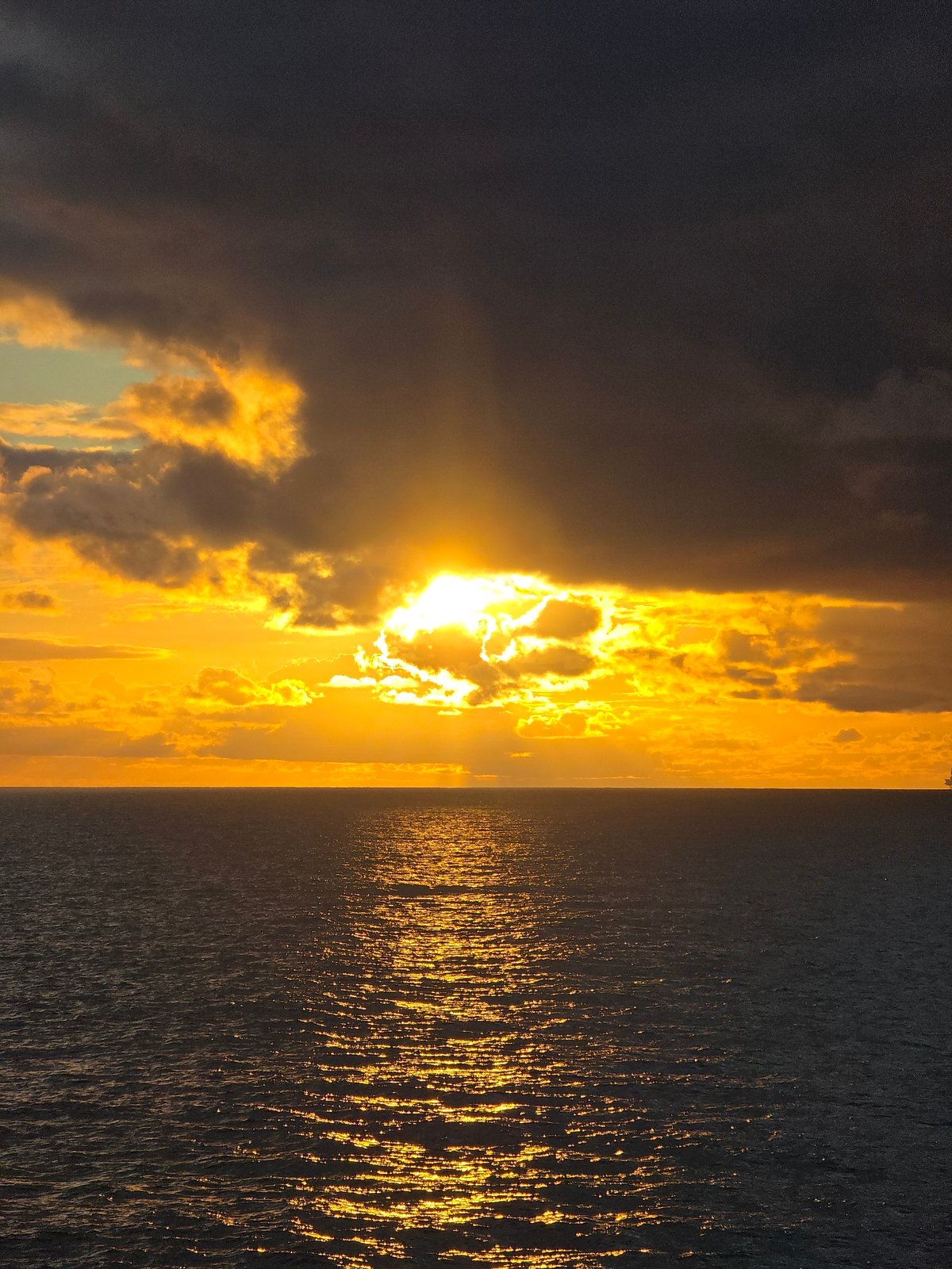 Sunset observed over water with golden light reflection