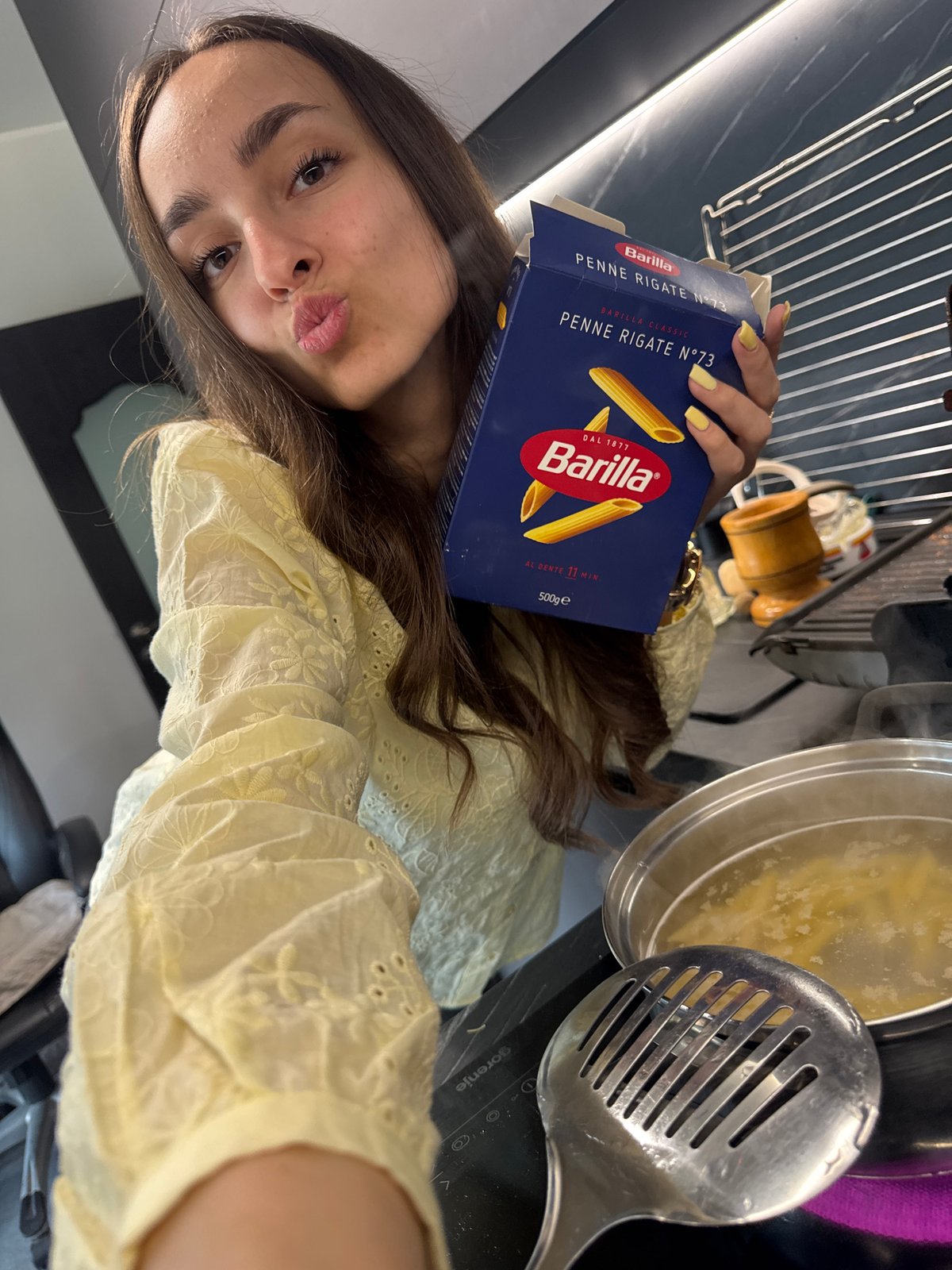 Woman cooks pasta, takes selfie in Sofia home