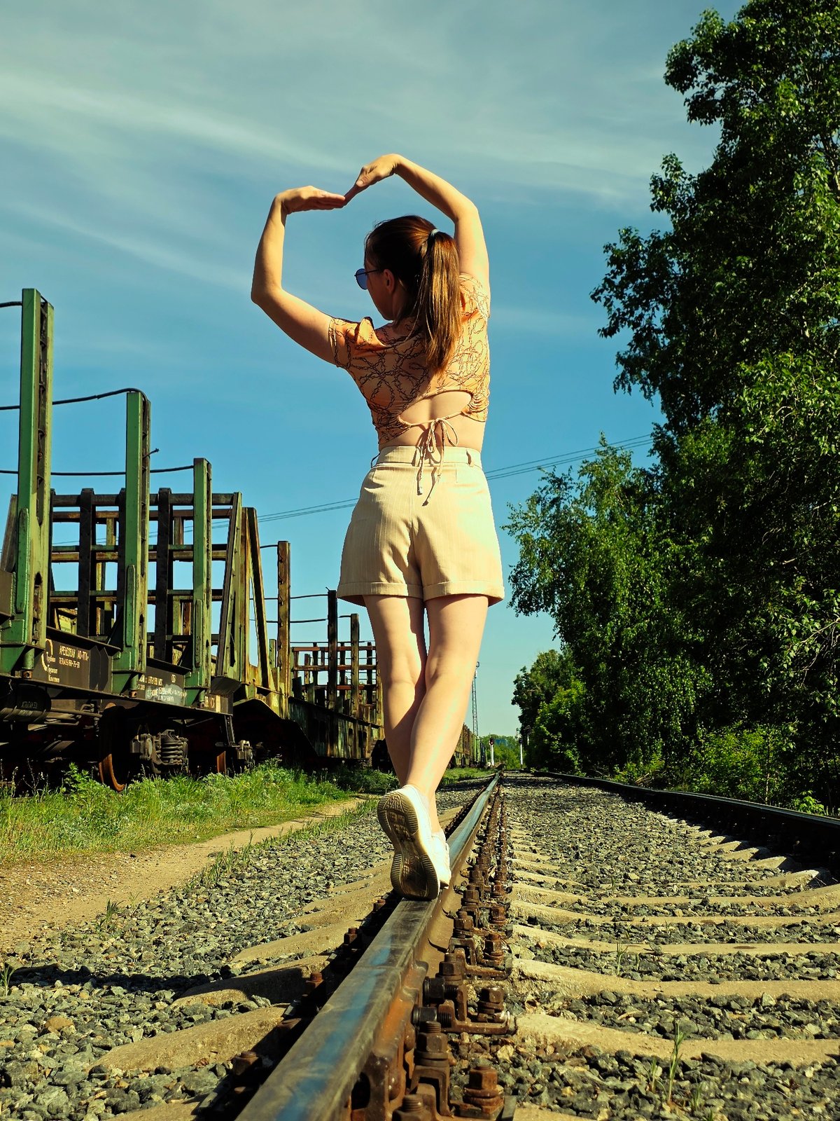 Woman walks on railroad tracks in Chaikovsky, Russia