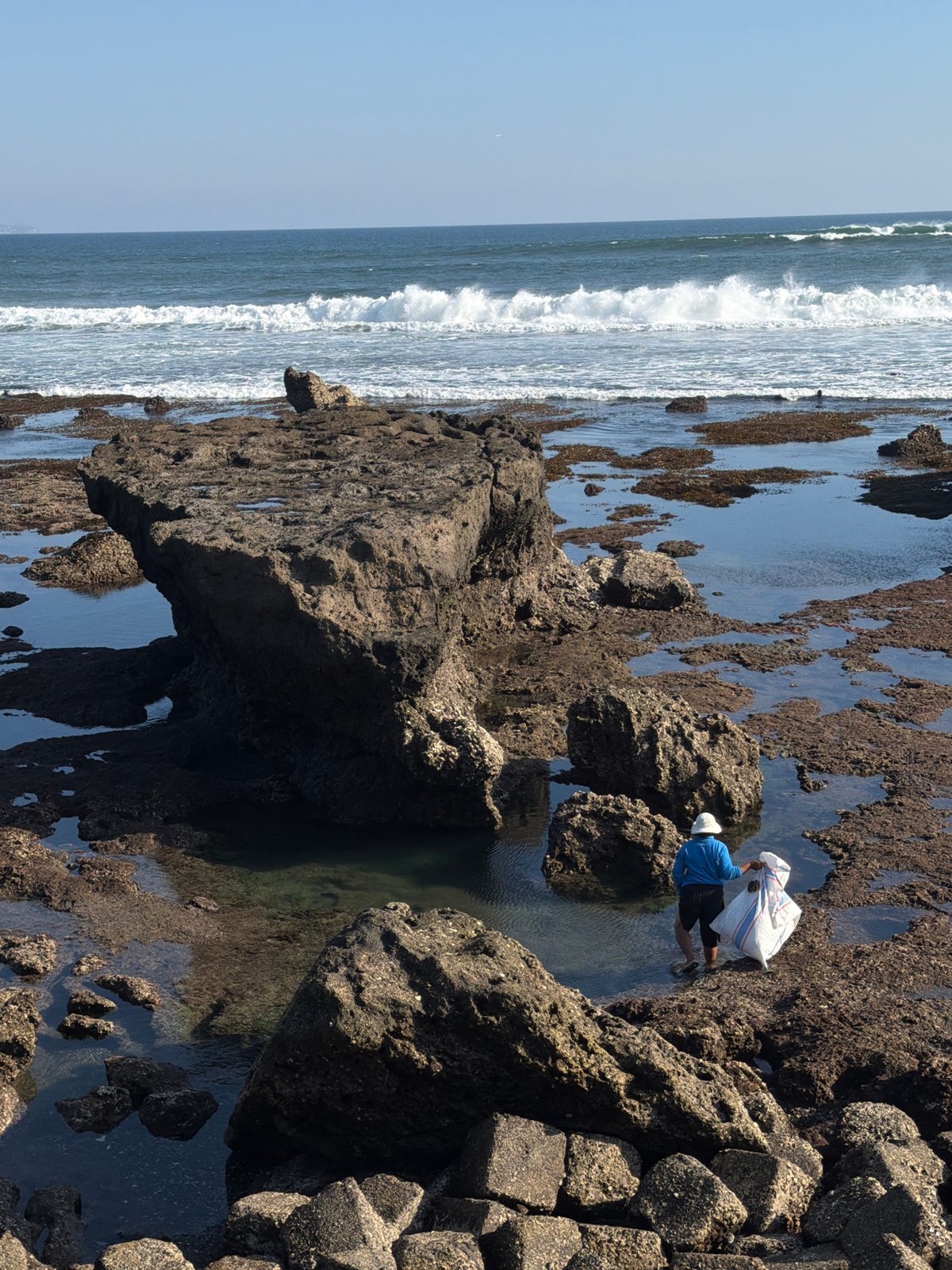 Beach cleanup, tourists, and a strawberry cart on North Kuta's shore