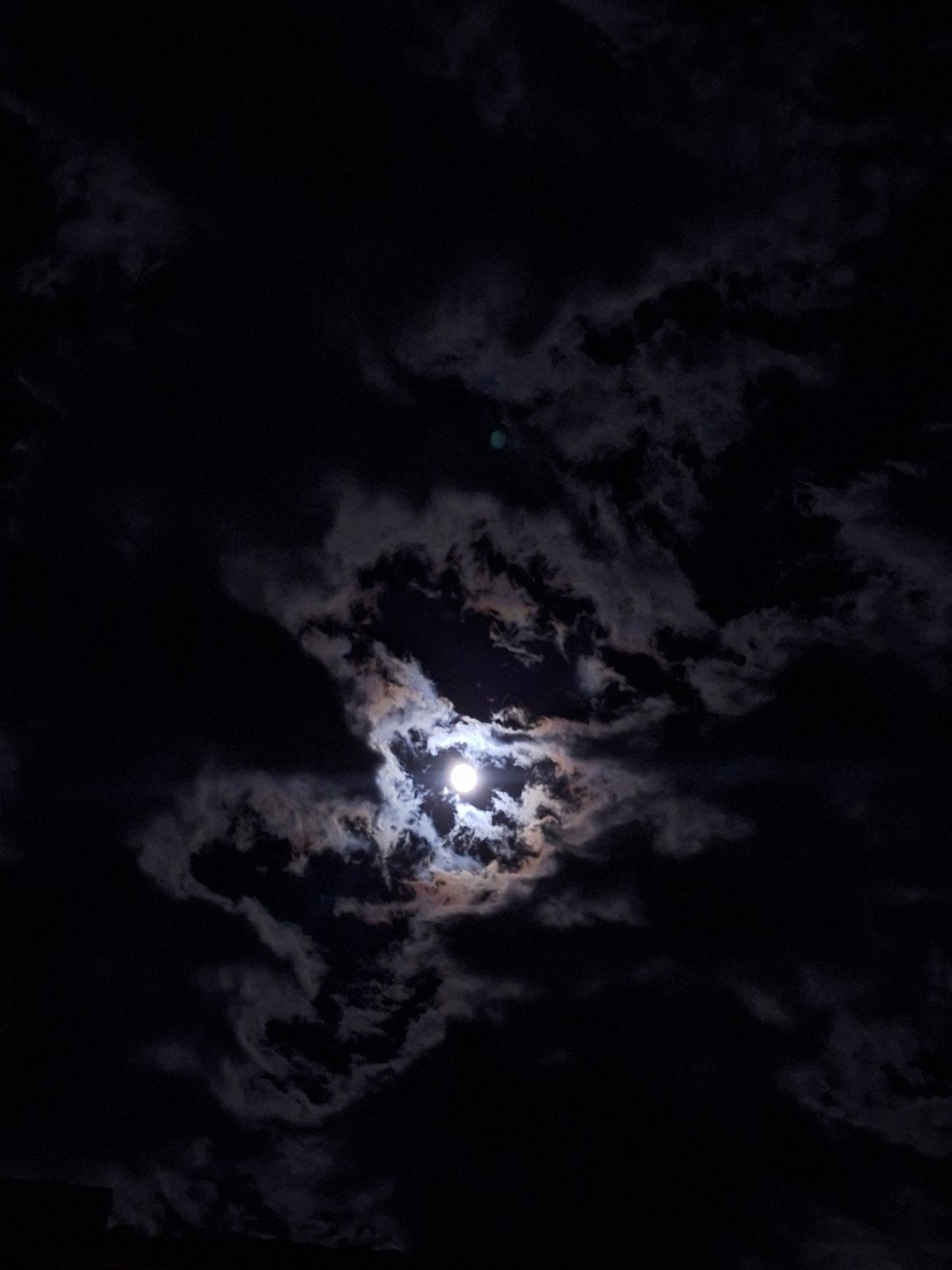 Dramatic moonlit sky observed through clouds over Bulgarian town