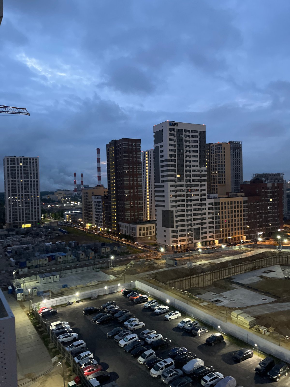 Moscow outskirts at twilight, parking lot and urban sprawl below