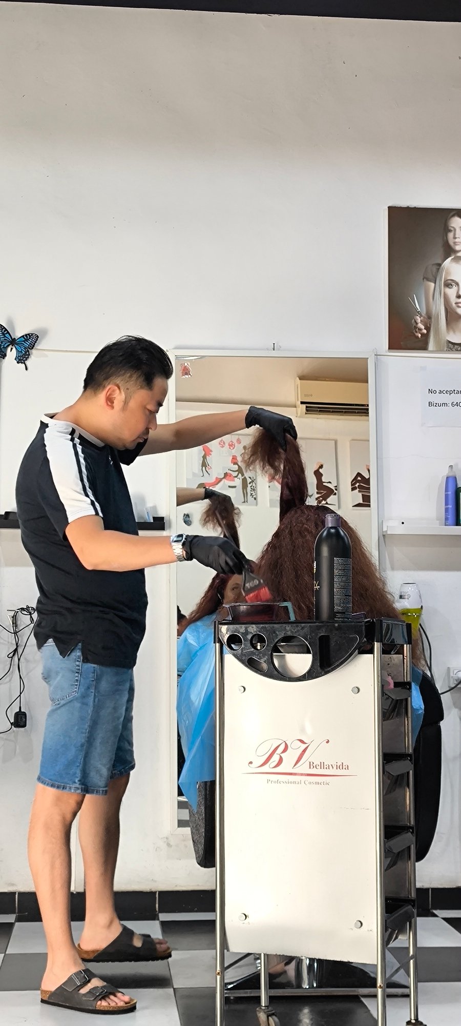 Hair stylist applies dye to client in Ripollet
