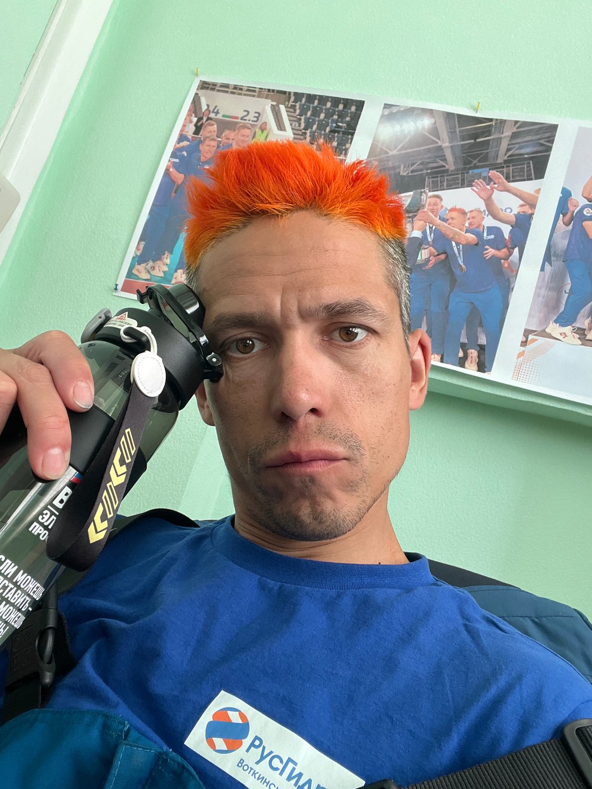 Orange-haired man takes selfie with water bottle in Chaikovsky
