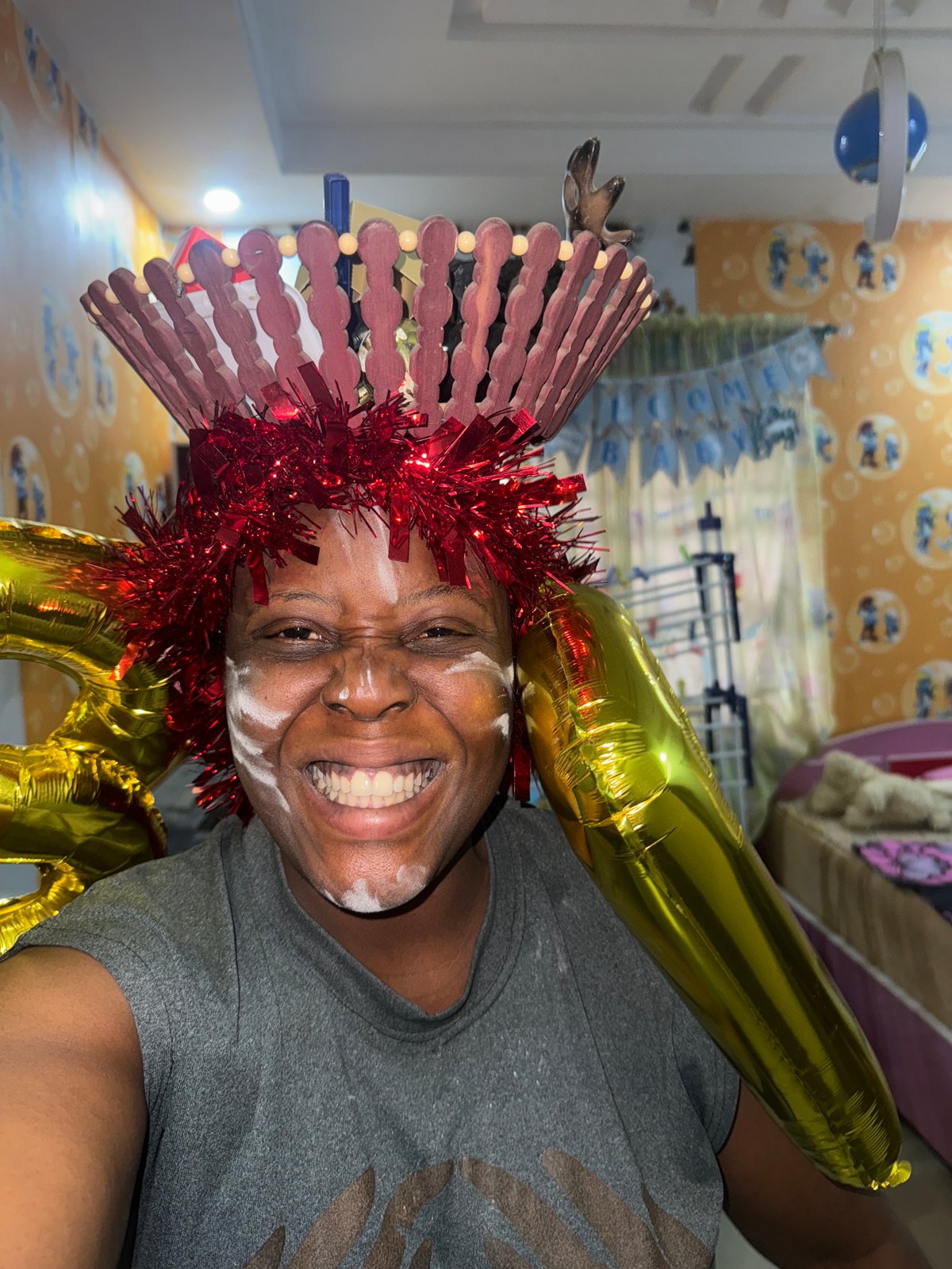 Person celebrates in festive costume with face paint and balloons