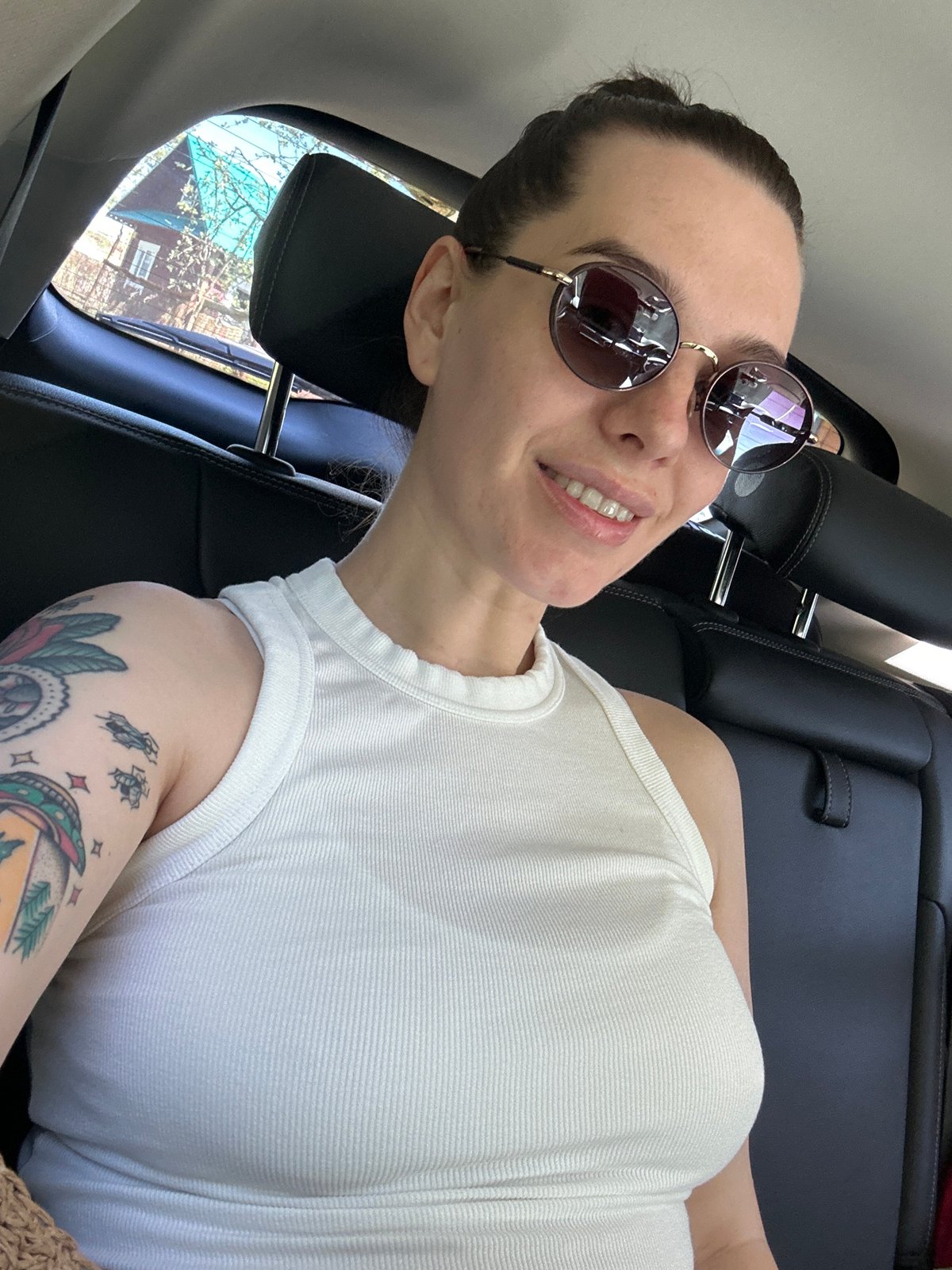 Woman in sunglasses observed in car backseat, Russia
