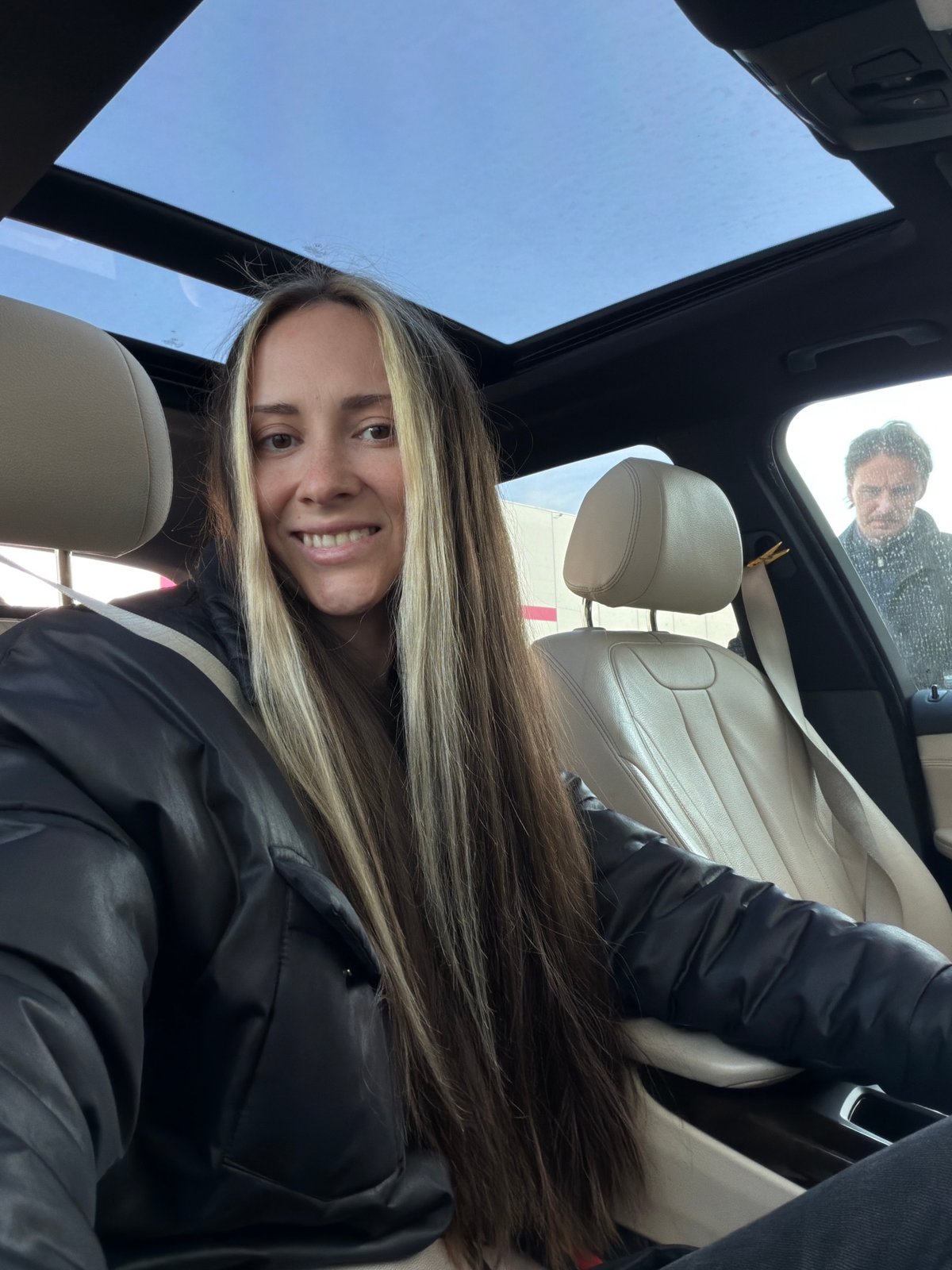 Woman photographed smiling in car with sunroof in Sluchainyi