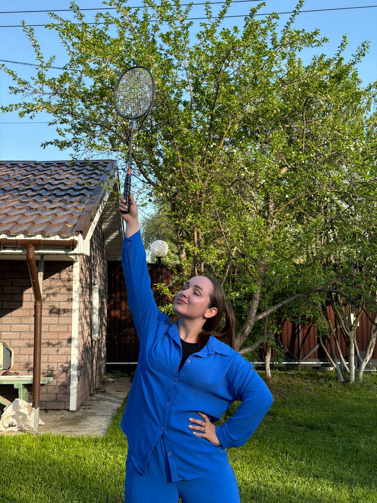 Family badminton gathering in Chaikovsky backyard during spring afternoon
