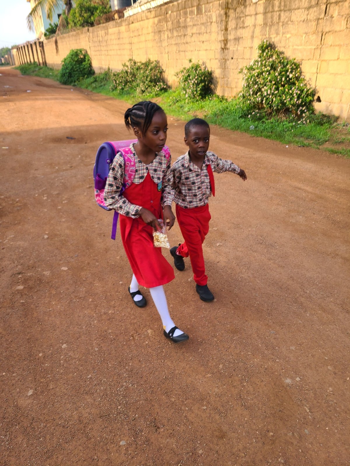 Children walk dirt roads in Jos Nigeria morning