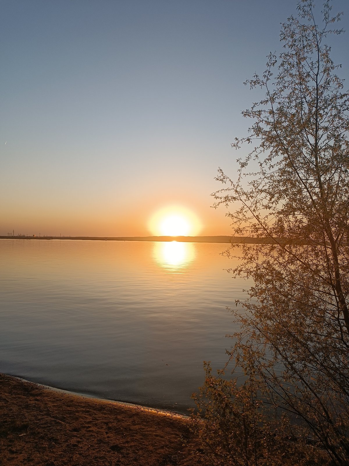 Woman captures sunset moments along Kama River in Chaikovsky