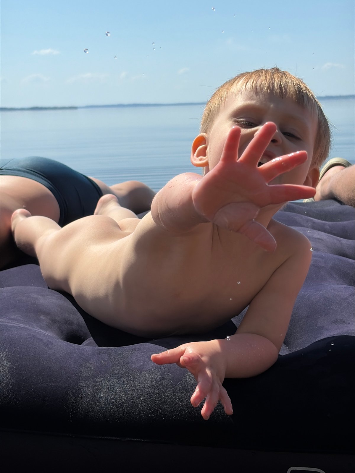 Child rests on inflatable raft in Zabegaevo waters
