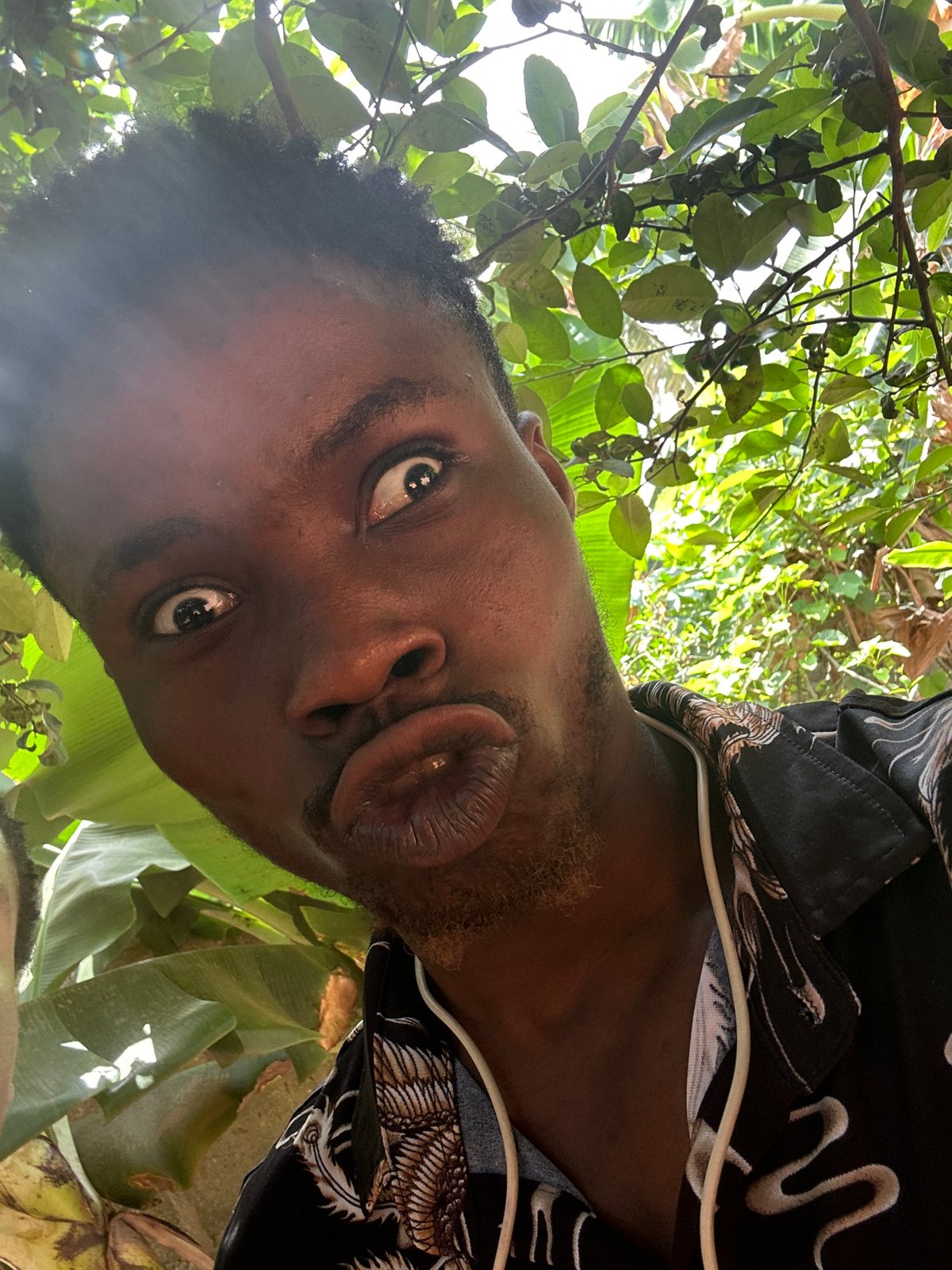 Man takes playful selfies among tropical plants during morning session