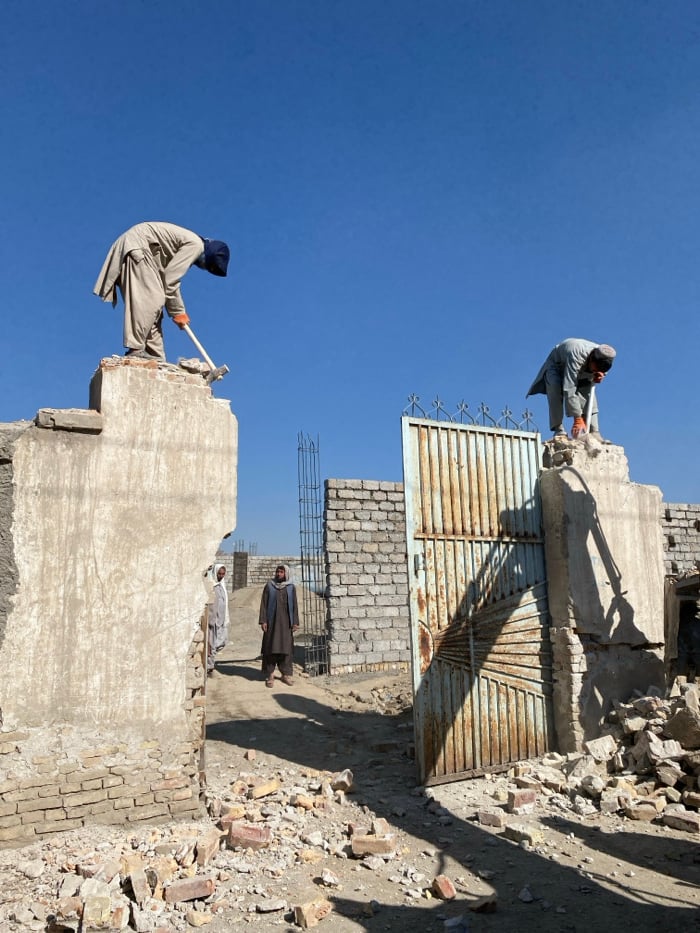Workers demolish concrete gate structures in Kandahar