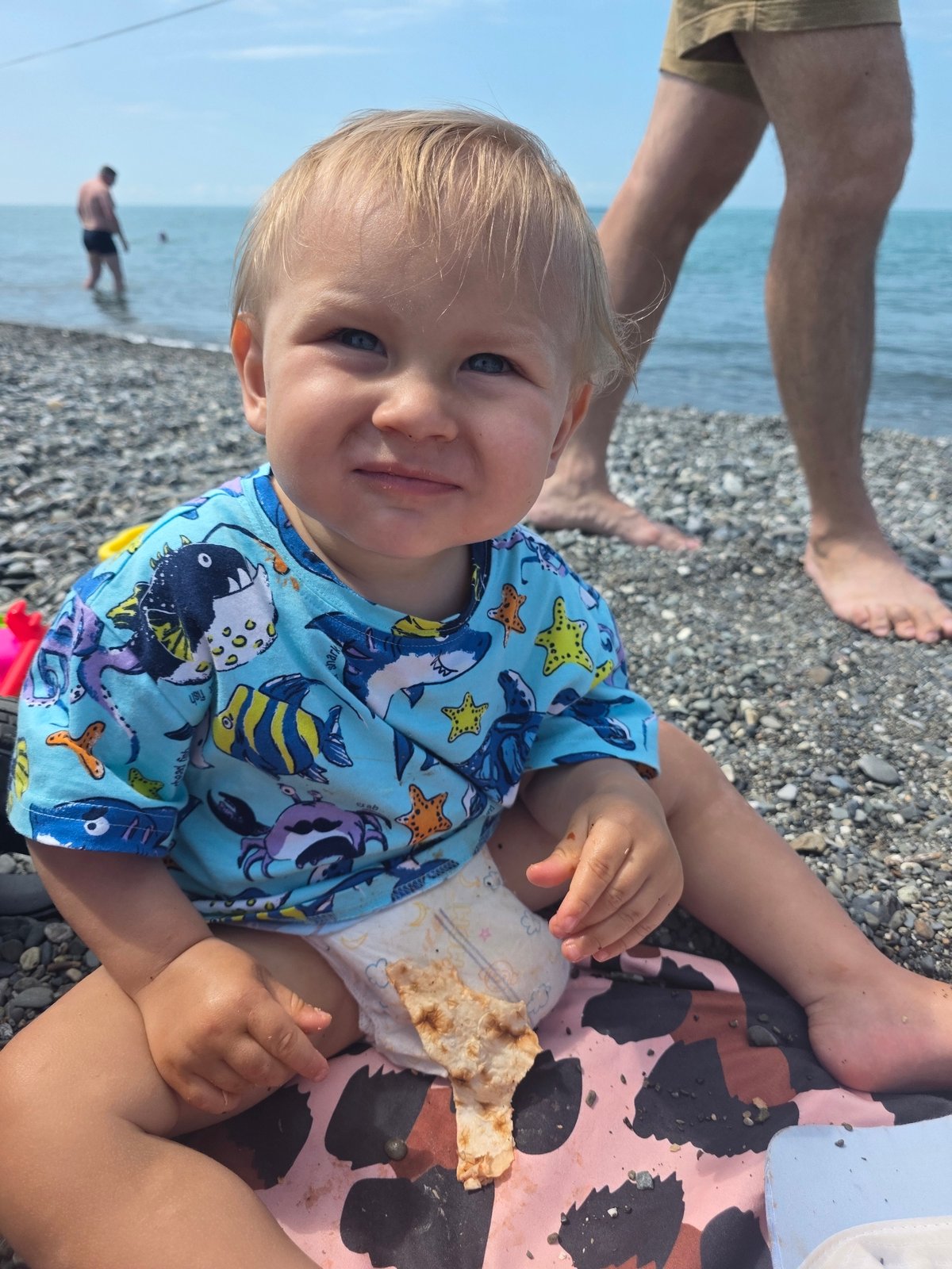 Toddler enjoys beach morning with flatbread in Sochi