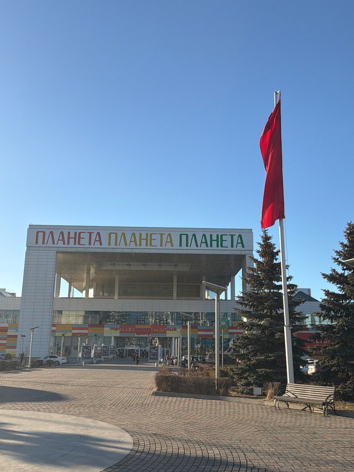 Red flag flies outside ПЛАНЕТА building in Krasnoyarsk